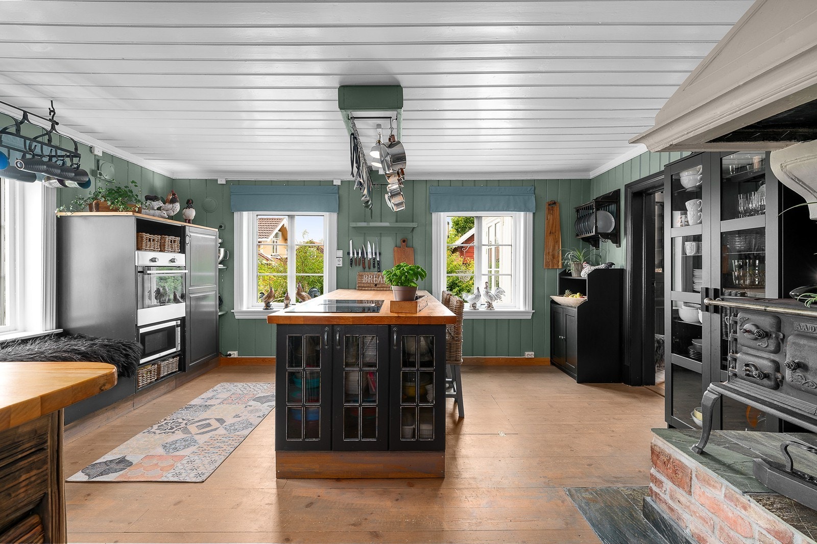 Stort kjøkken med delvis integrerte hvitevarer og mye skap- og benkeplass Galleribilde