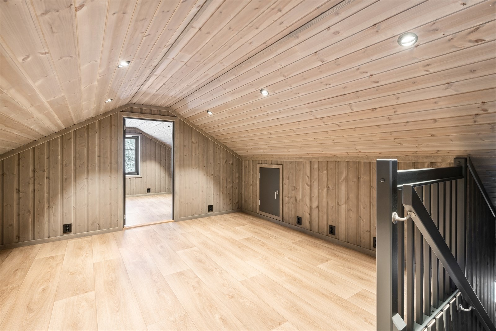 Loftsetasjen har sjarmerende skråtak med downlightsbelysning, og i det største rommet er det vindu inn til stue/kjøkken i hovedetasjen. Galleribilde