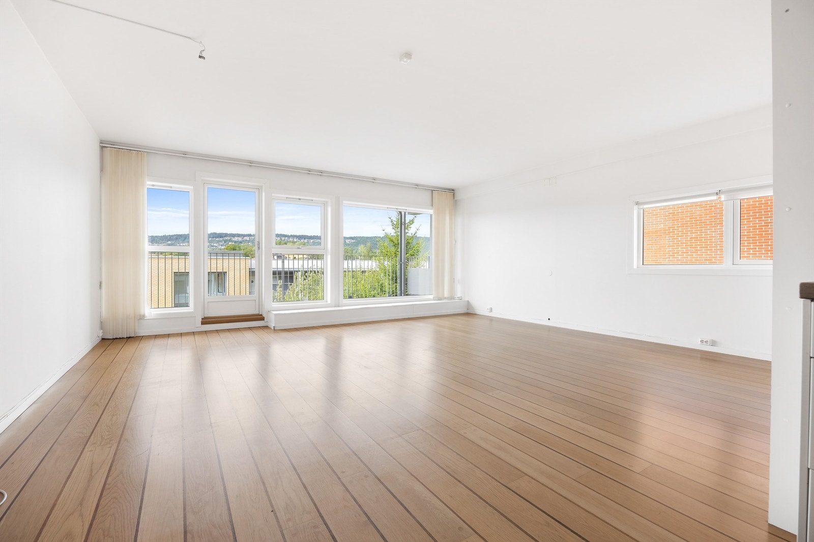 Stuen har store vindusflater som slipper inn rikelig med naturlig lys Galleribilde