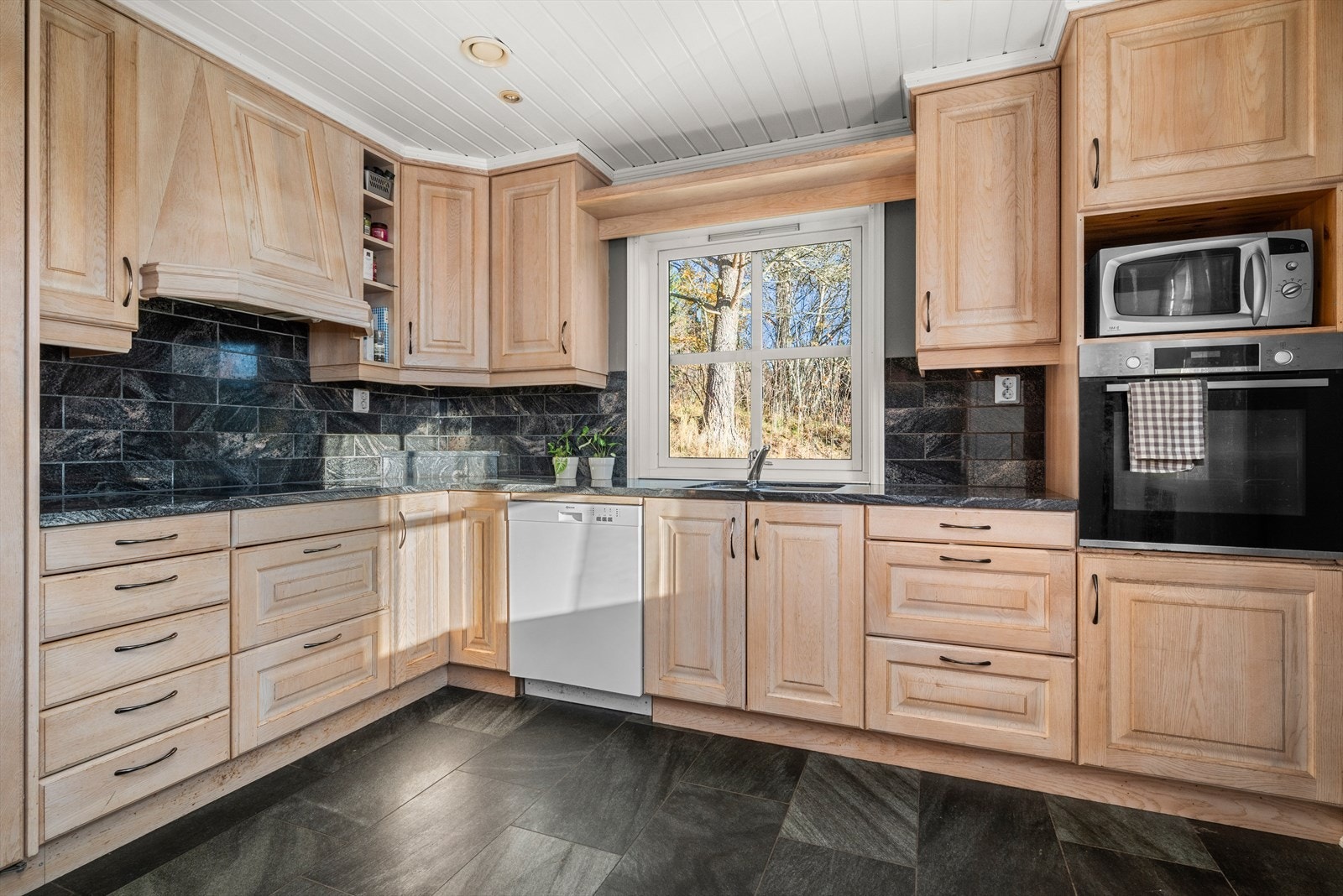 Kjøkkenet har rikelig med skap- og benkeplass og er utstyrt med integrert stekeovn og platetopp. Frittstående oppvaskmaskin og kjøleskap medfølger i handelen. Galleribilde