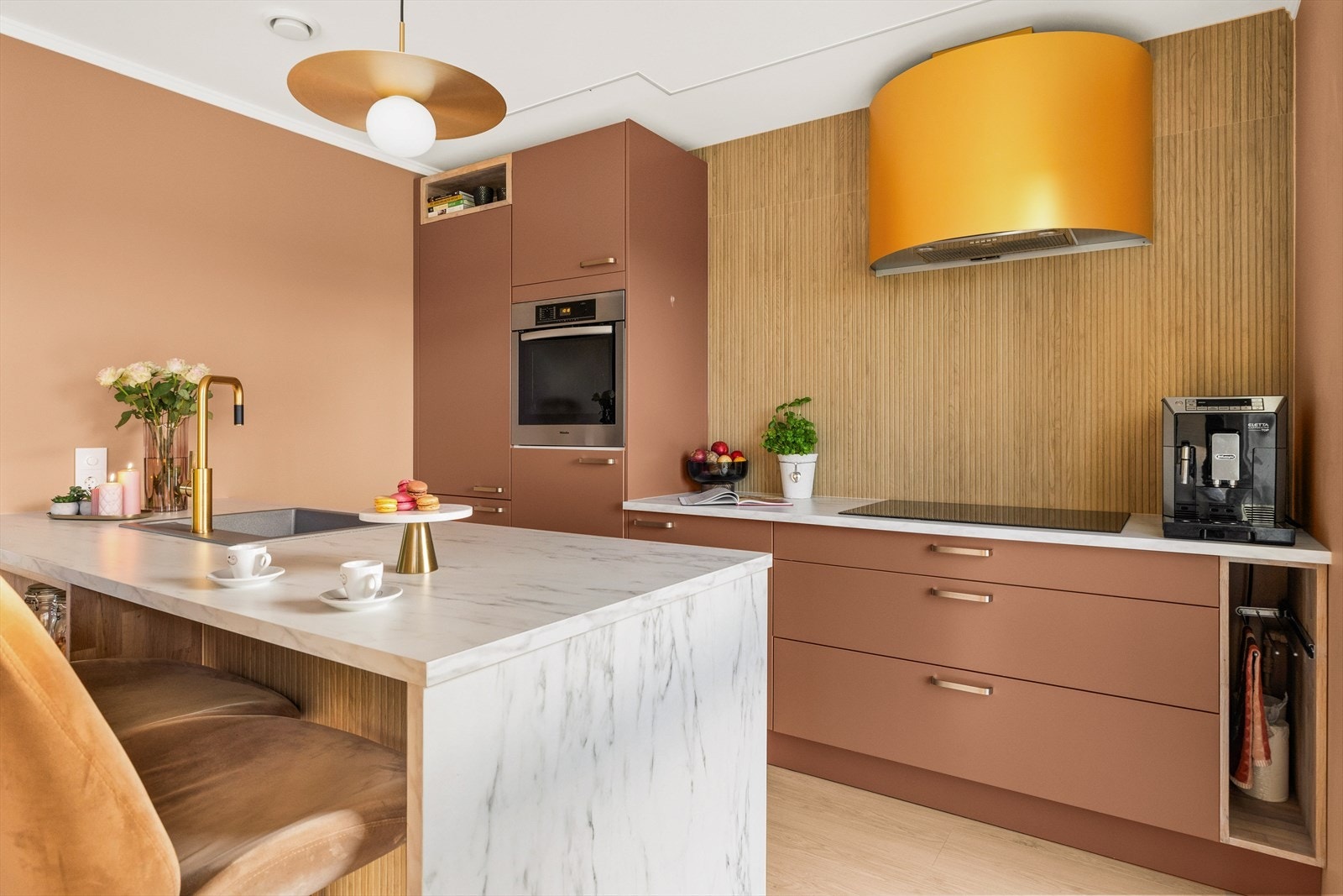 Innredningen har slette fronter i dempede jordtoner og benkeplate i laminat med detaljer i lys steinimitasjon. Galleribilde