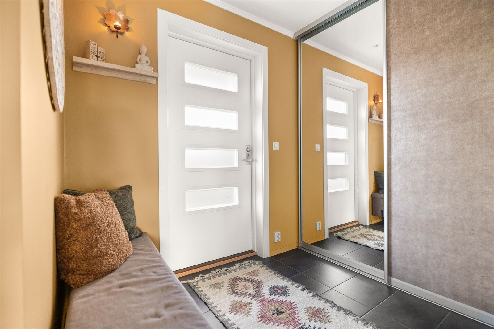 Flislagt entré med praktisk skyvedørsgarderobe. Galleribilde