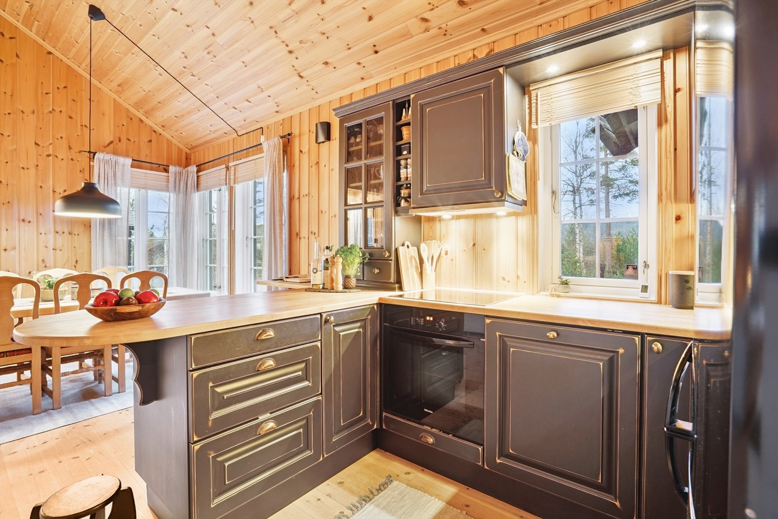 Heltre kjøkkeninnredning med malte profilerte fronter og et skap med glass i front. Benkeplaten er i heltre med nedfelt oppvaskkum i stål. Galleribilde