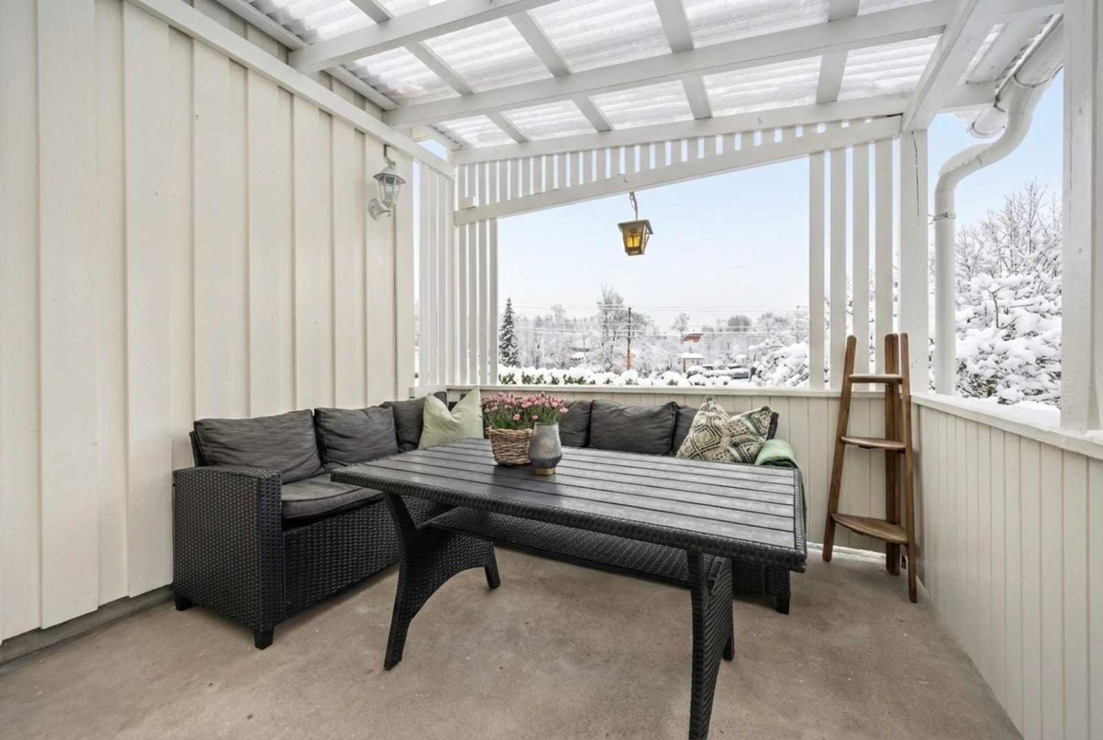 Fra stuen er det utgang til en lun, overbygget terrasse på ca. 13 kvm. Bildet er kunstig redigert med KI og er kun ment som en illustrasjon. Galleribilde