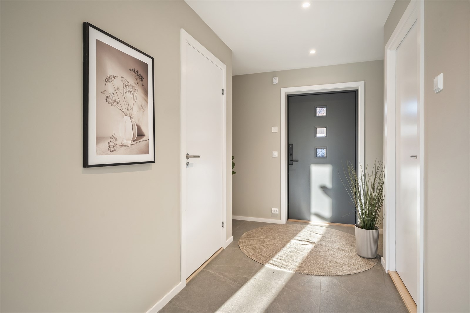 Velkommen inn i en lys entré med adkomst til bad og vaskerom. Galleribilde