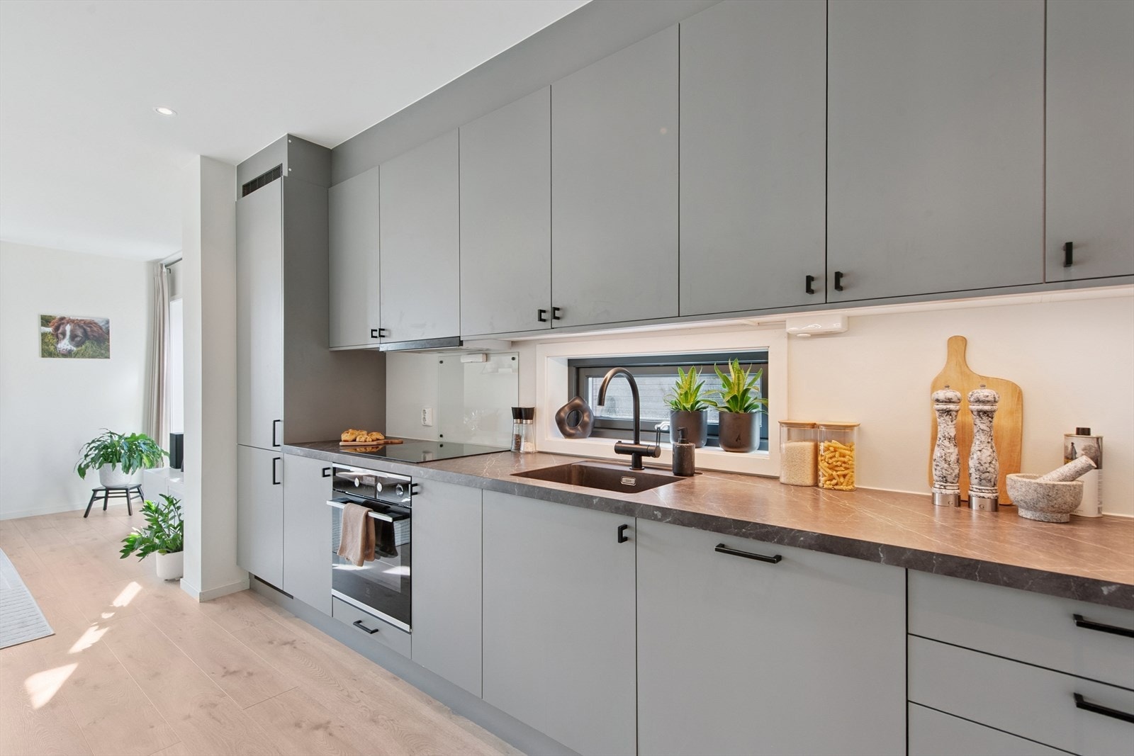 Kjøkkeninnredning med glatte fronter, laminat benkeplate og integrerte hvitevarer. Galleribilde