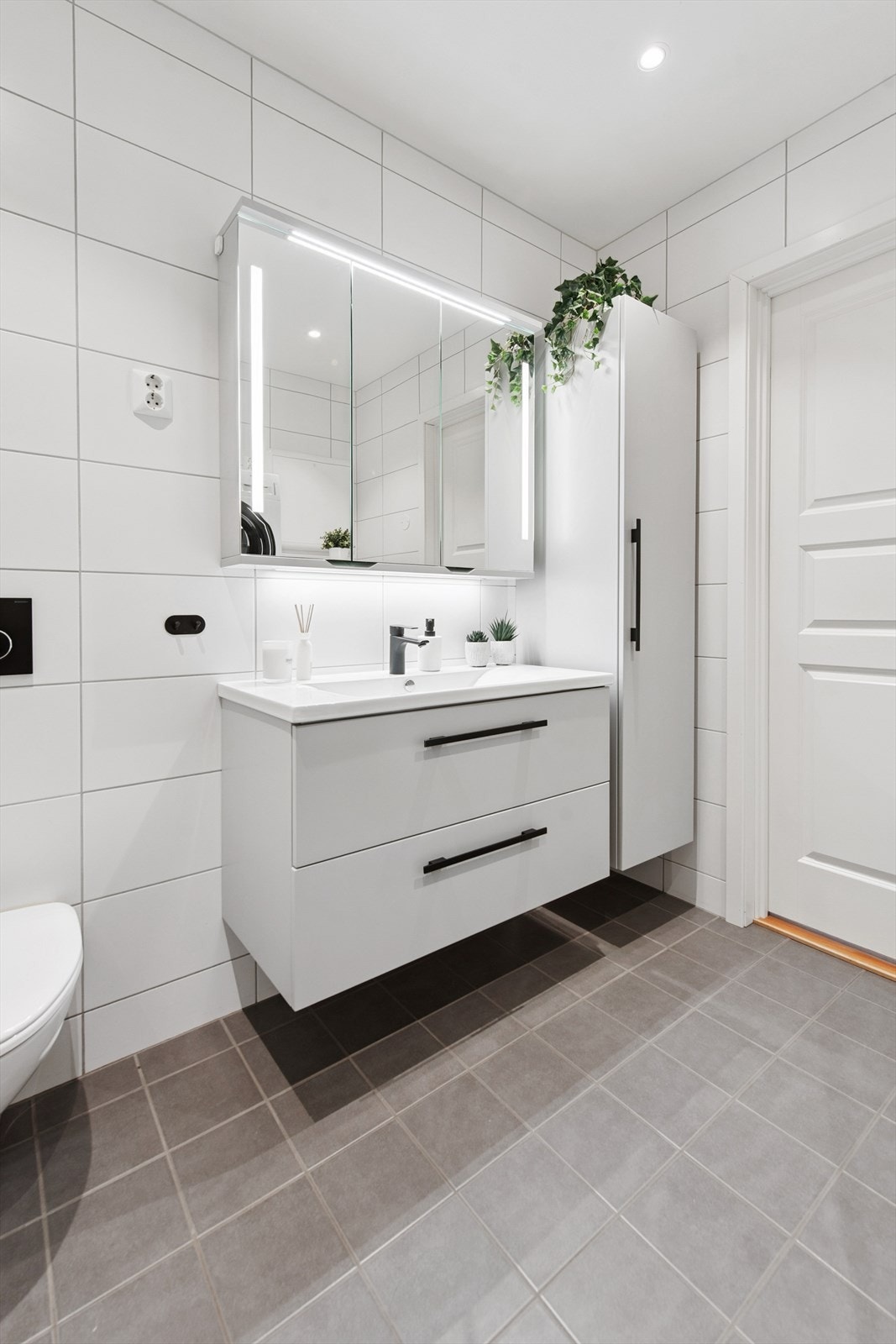 Baderomsinnredning med nedfelt servant og god oppbevaringsplass i skuffer og høyskap. Galleribilde