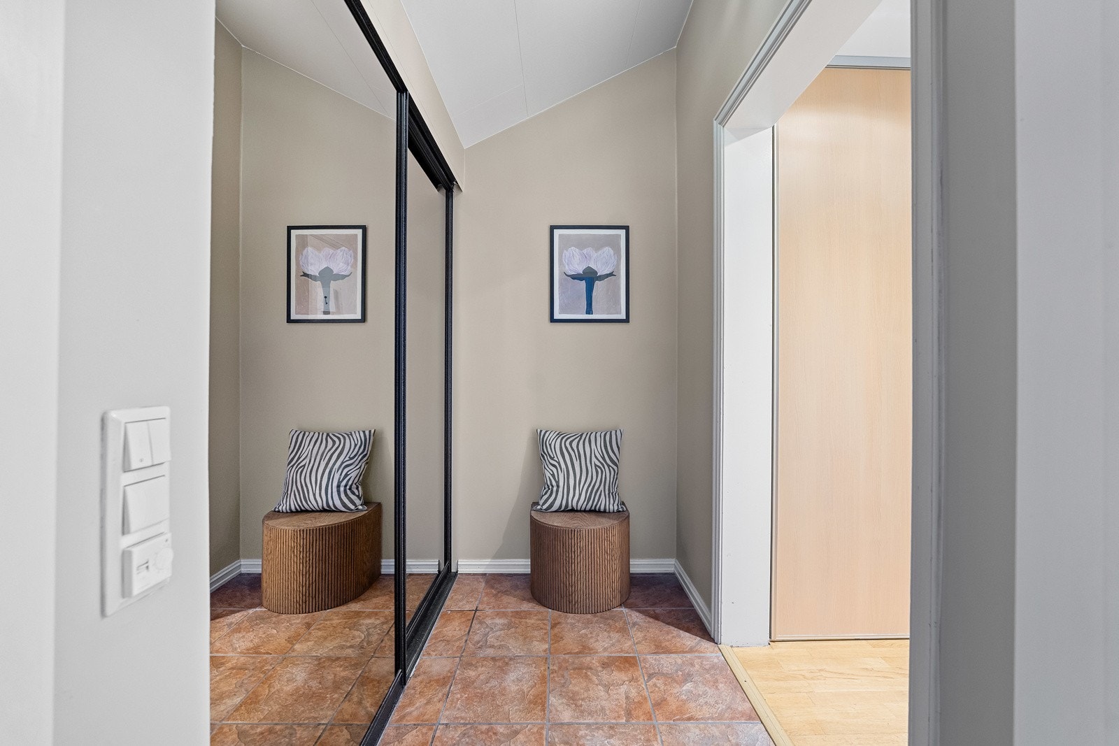 Inngangspartiet gir et svært godt førsteinntrykk med praktiske fliser, og lyse vegger. Det er god plass til oppheng og oppbevaring i en funksjonell skyvedørsgarderobe. Galleribilde