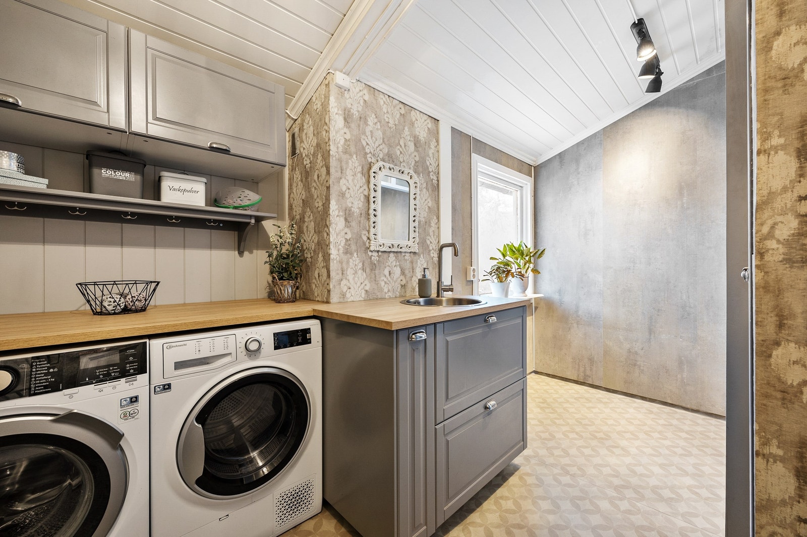 Praktisk og funksjonelt vaskerom av ukjent opprinnelig årstall, oppgradert i 2017. Rommet har gulvbelegg med gulvvarme og moderne innredning. Speil på vegg samt opplegg for vaskemaskin og tørketrommel Galleribilde