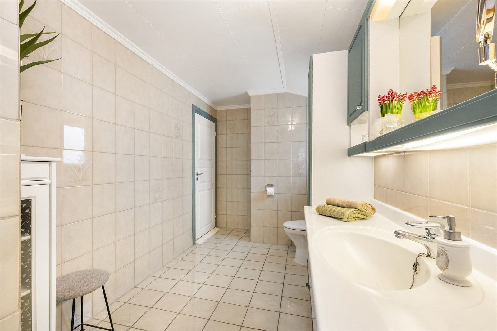 Rommet har flislagt gulv med gulvvarme samt flislagte vegger. Gulvstående toalett Galleribilde