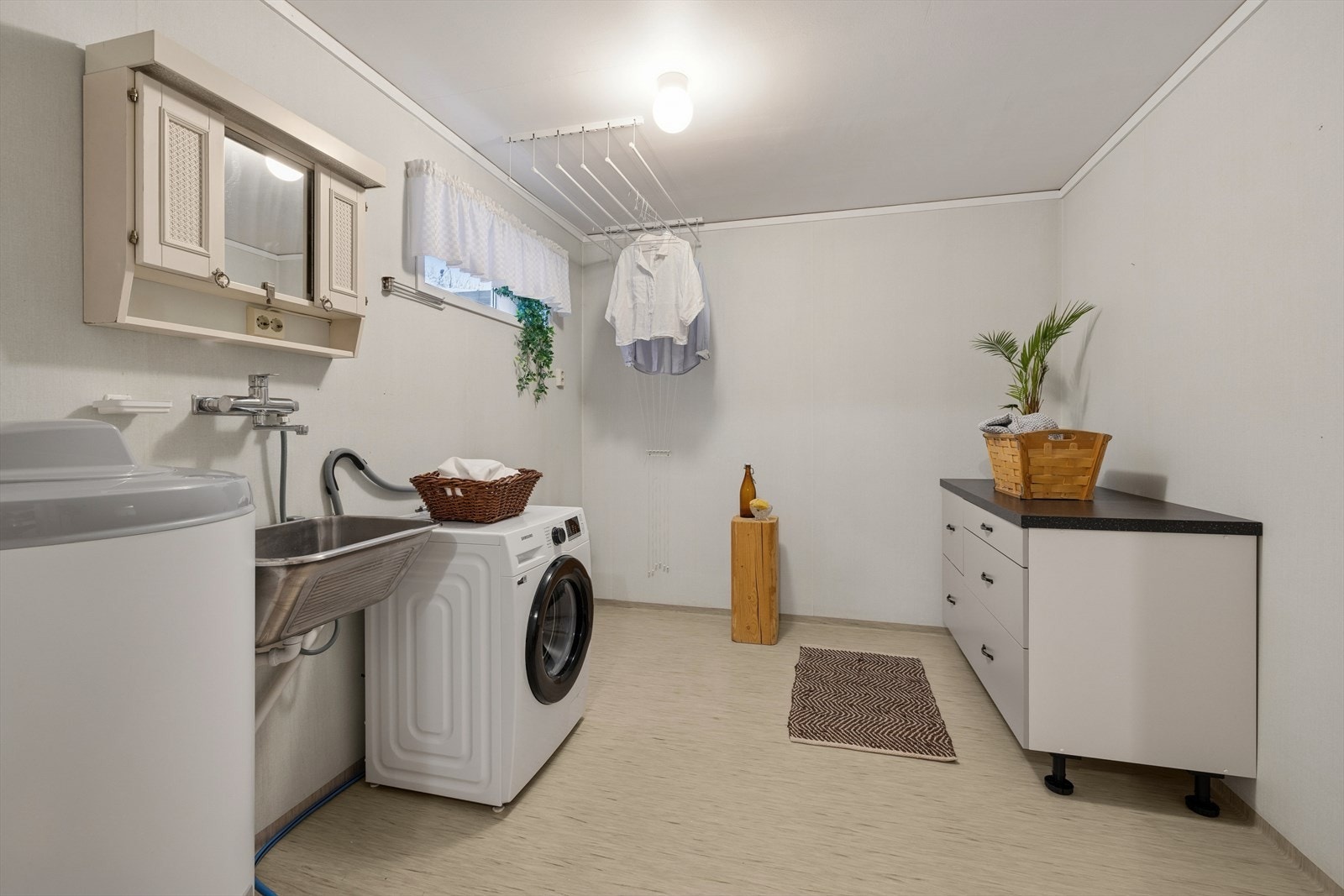 Vaskerommet har gulvbelegg og himlingsplater, med avtrekksvifte og ventilasjon i himling for effektiv luftutskiftning. Galleribilde