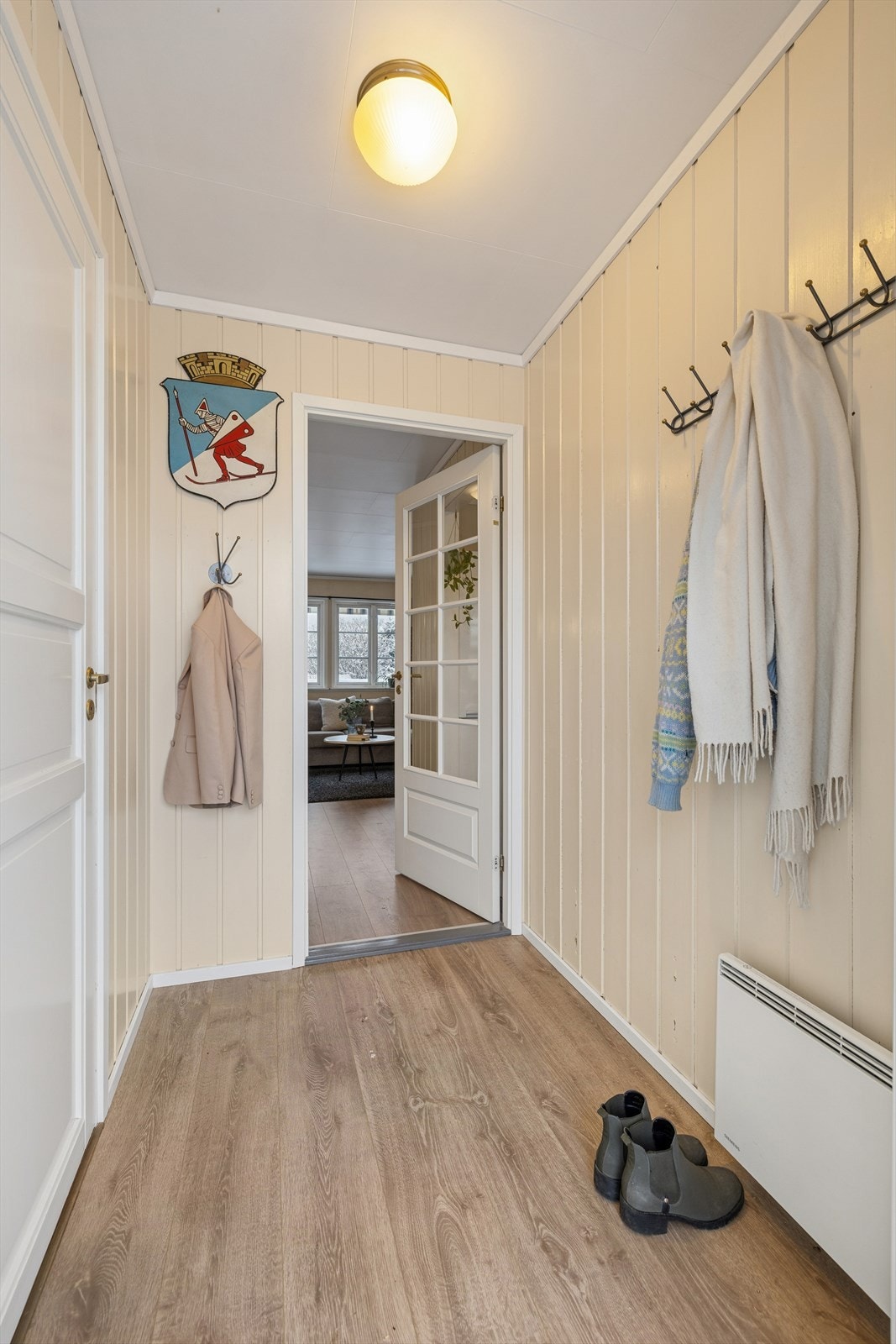 Gulv i entréen er dekket med laminat, og veggene har panel som gir et klassisk utseende. Galleribilde