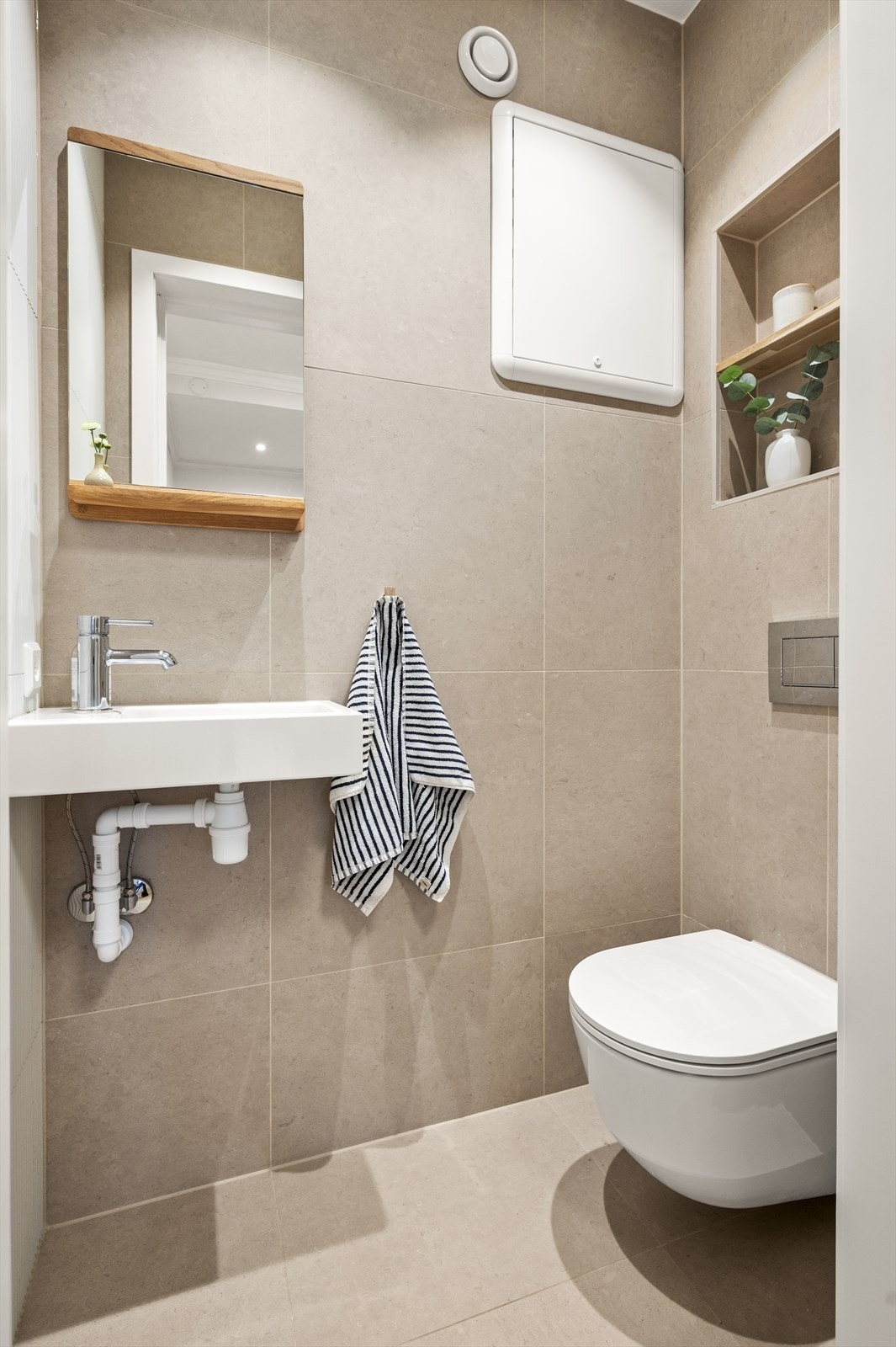 Toalettrommet er flislagt, har gulvvarme, vegghengt klosett og servant. Galleribilde