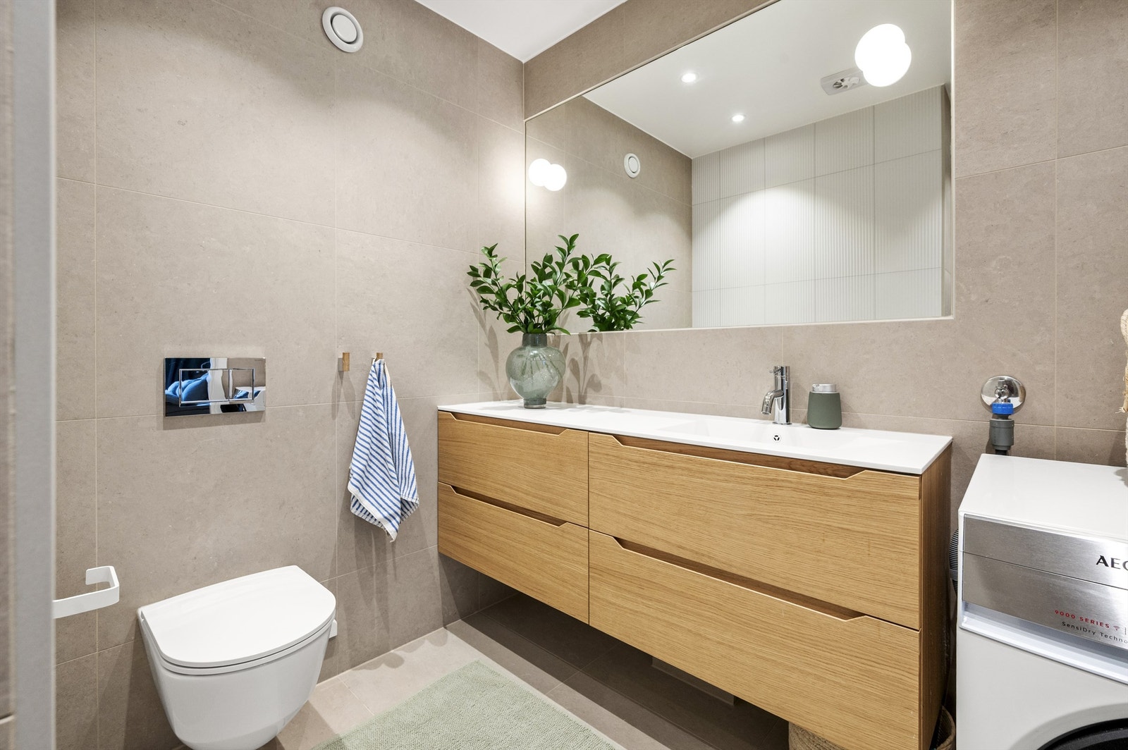 Innredningen består av en bred servant med skuffer, vegghengt toalett og et stort, innfelt speil. Galleribilde