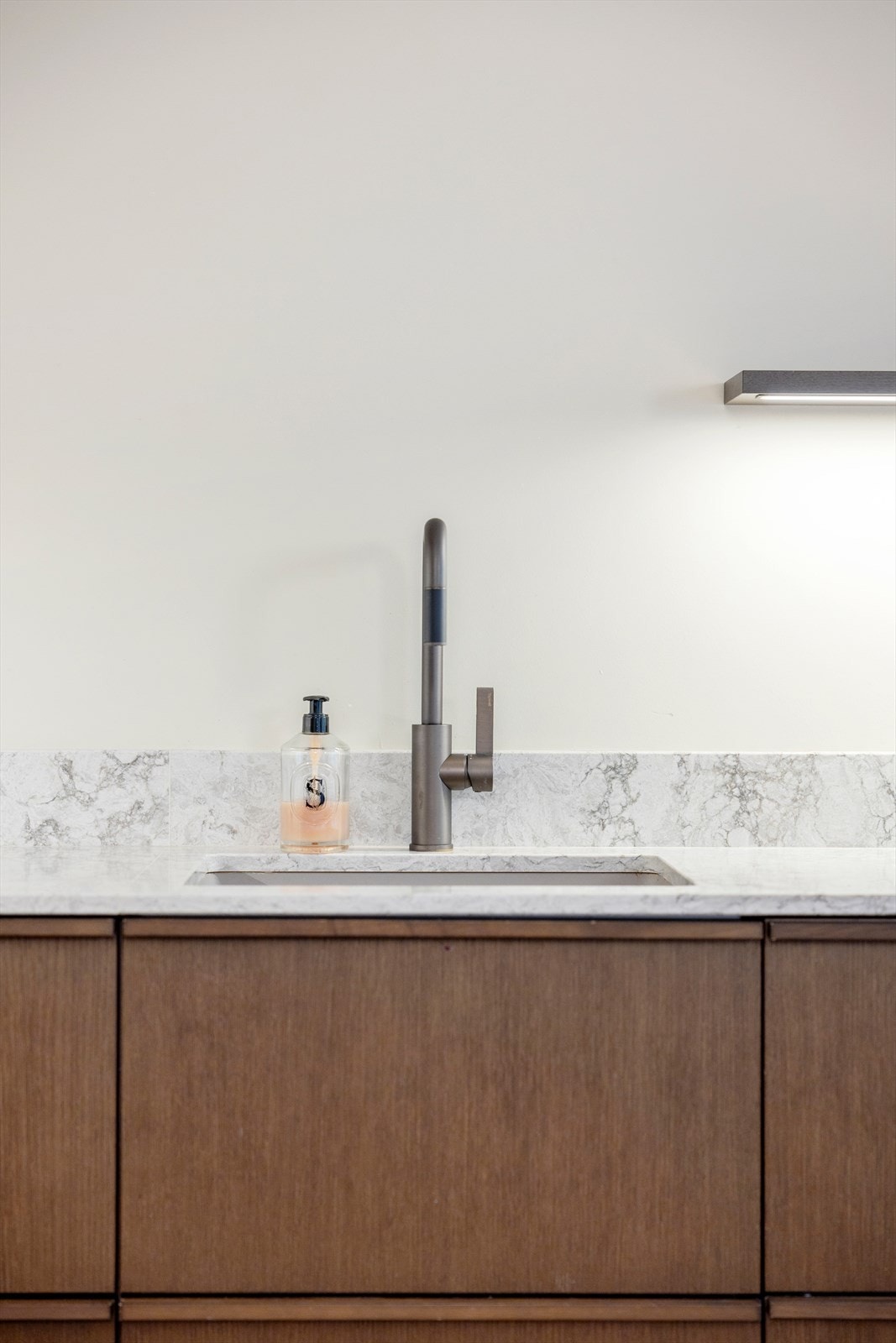 Solid benkeplate i kvartskompositt med underlimt kum. Bronsefarget Tapwell-kran som matcher håndtakene i leiligheten Galleribilde