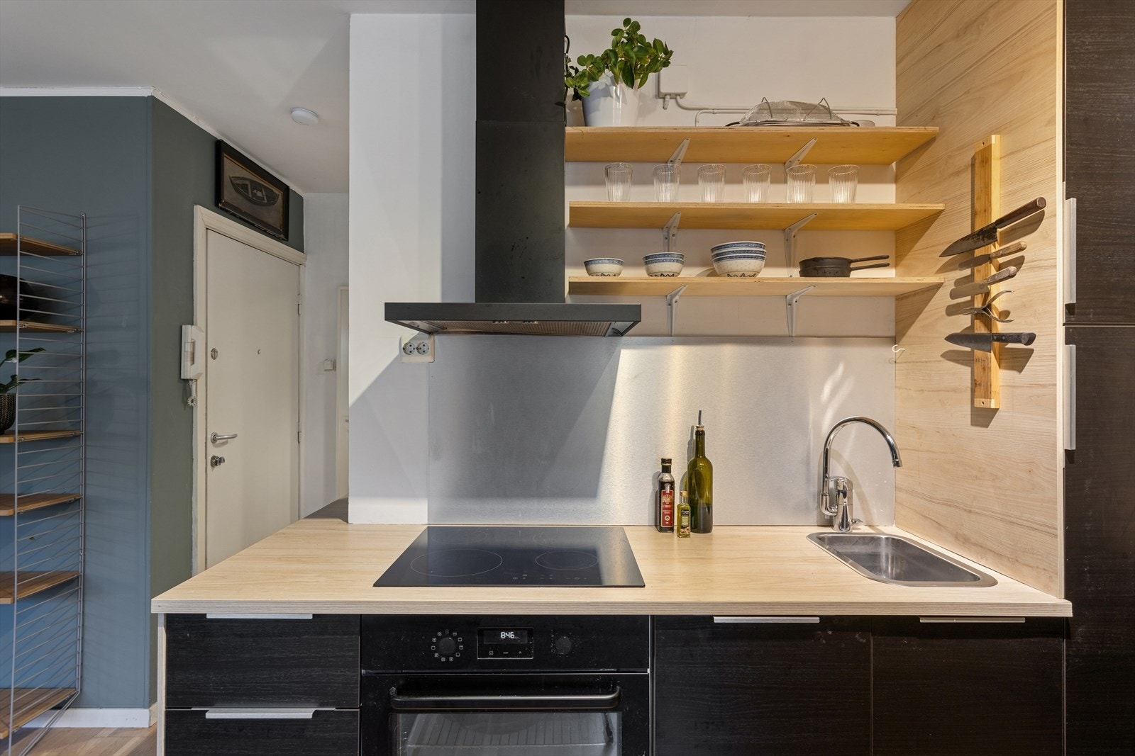 Kjøkkeninnredning med slette finerte fronter, laminat benkeplate m/sprutplate over, enkel oppvaskkum, kjøkkenventilator i stål, integrert koketopp,
stekeovn, oppvaskmaskin og kjøleskap. Galleribilde