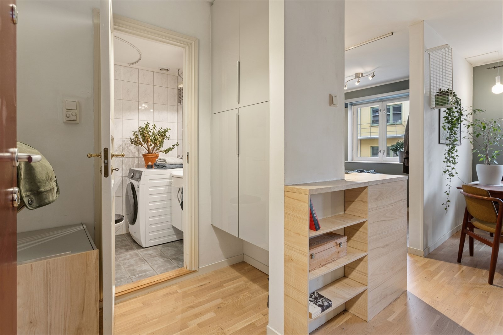 Boligen har en innbydende entré med lyse vegger og lekker eikeparkett. Her har du god plass til å legge fra deg sko og henge fra seg yttertøy både på opphengte knagger og praktisk skap. Galleribilde