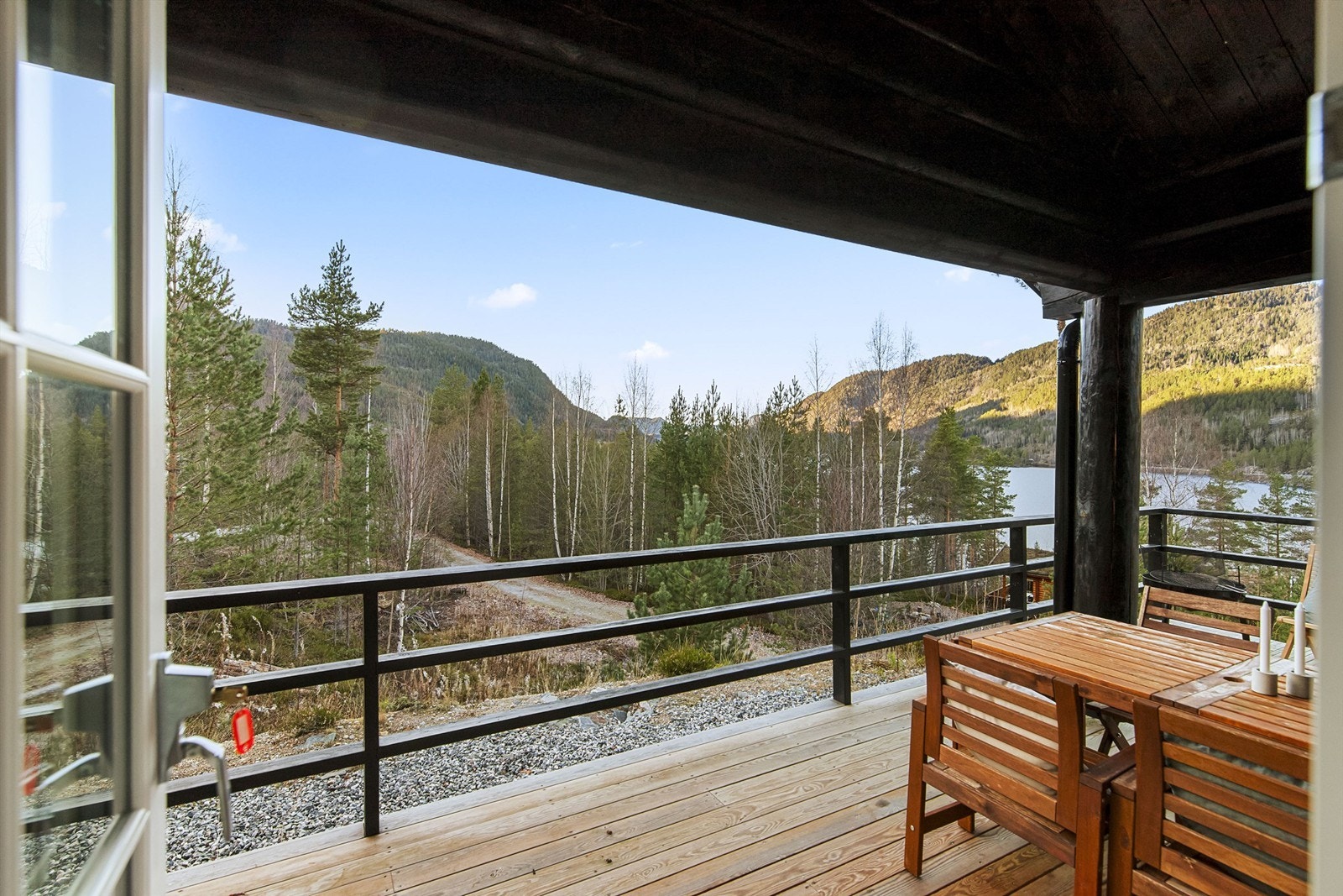 Flere koselige uteplasser på terrassen. Her sitter man lunt og under tak med utgang fra stuen Galleribilde