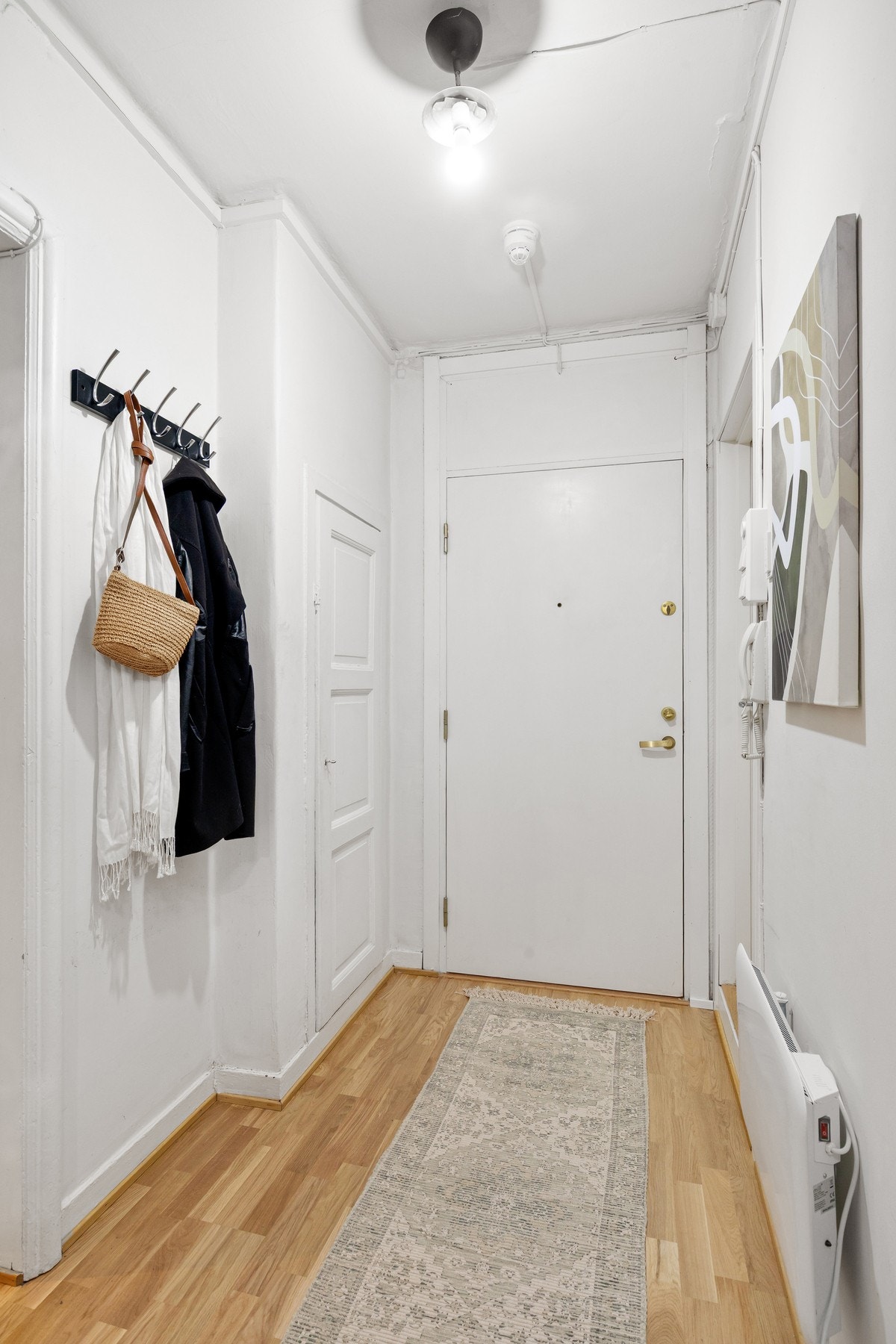 Lys og innbydende entré med plass til oppbevaring av sko og yttertøy. Plassbygd kott og skoskap. Galleribilde