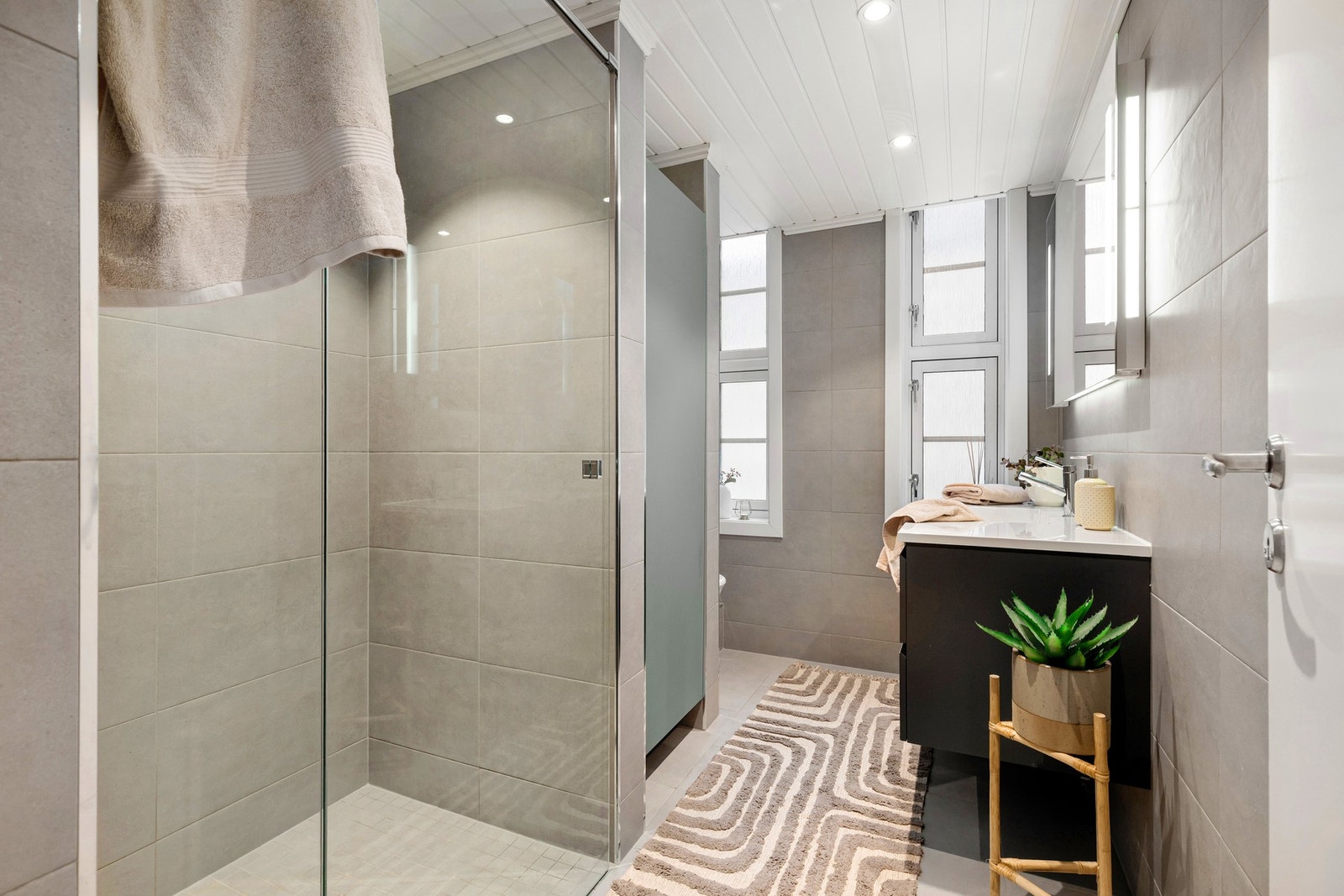 Utvidet og delikat bad fra 2017, flislagt i tidløs stil med varmekabler i gulvet og downlights. Galleribilde