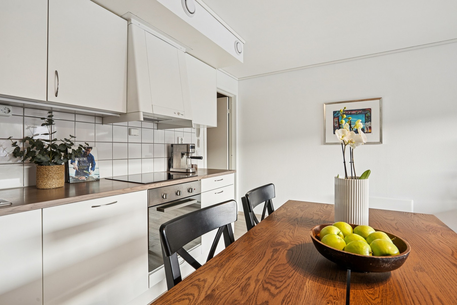 Kjøkken er innredet med mekanisk avtrekksvifte over stekesonen. Det er integrert kjøl/fryseskap, oppvaskmaskin og platetopp. Galleribilde