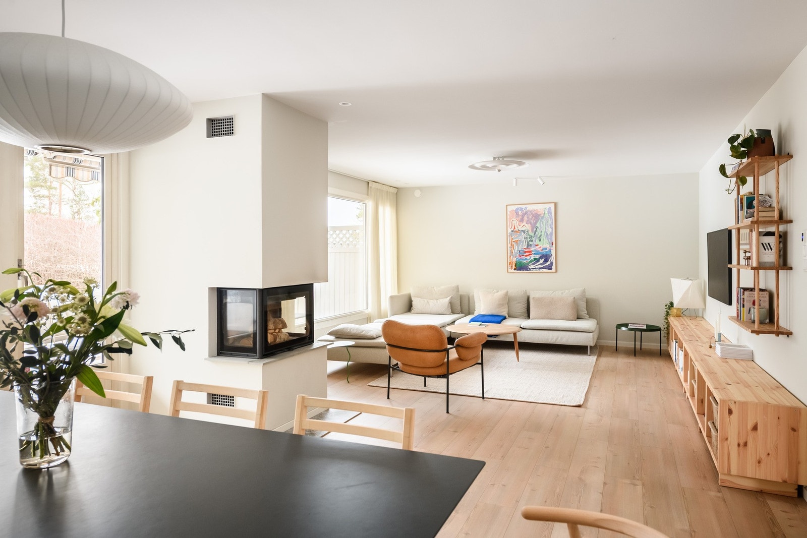 Fra peisen åpner rommet seg mot sofagruppen med god avstand og naturlig møblering. Galleribilde