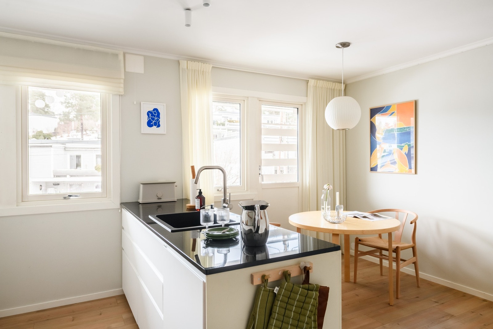 Lyst kjøkken der spiseplassen er integrert i planløsningen og gir en naturlig flyt i rommet. Her kommer morgensola inn på sommeren. Galleribilde