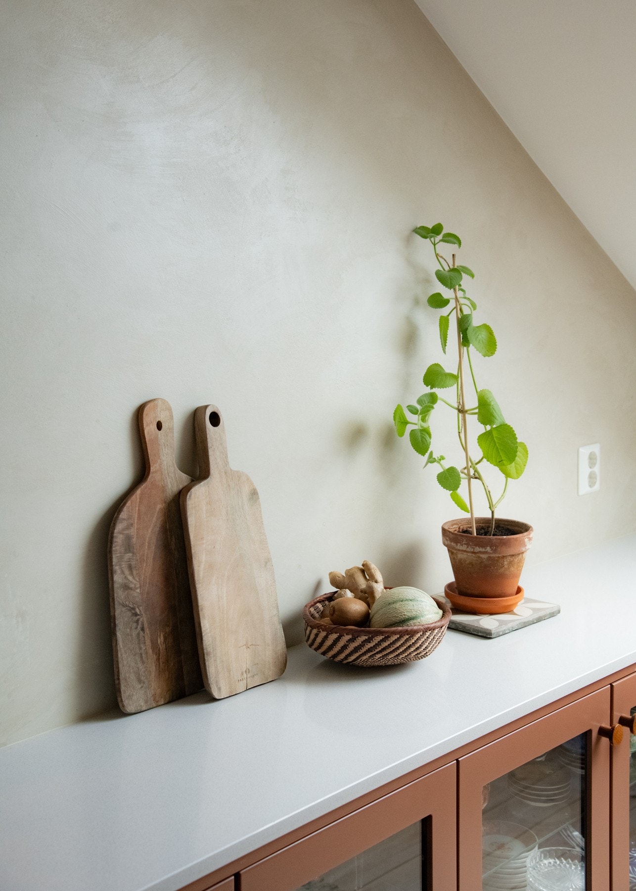 Mellom benkeplate og underskap er det murte, pussede vegger som tilfører rommet særpreg og en taktil kontrast til de rene flatene. Galleribilde