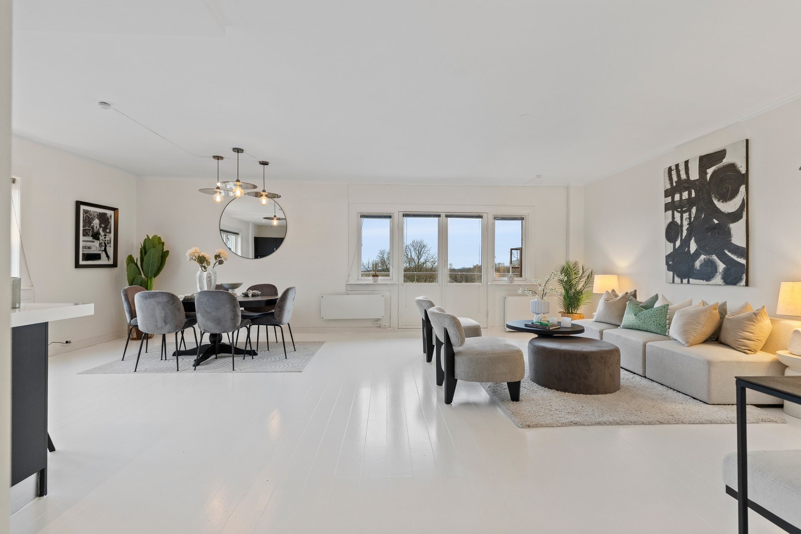 Stuen i leiligheten er romslig og flott opplyst med store vindusflater som gir rikelig med naturlig lys, og skaper en god atmosfære. Galleribilde