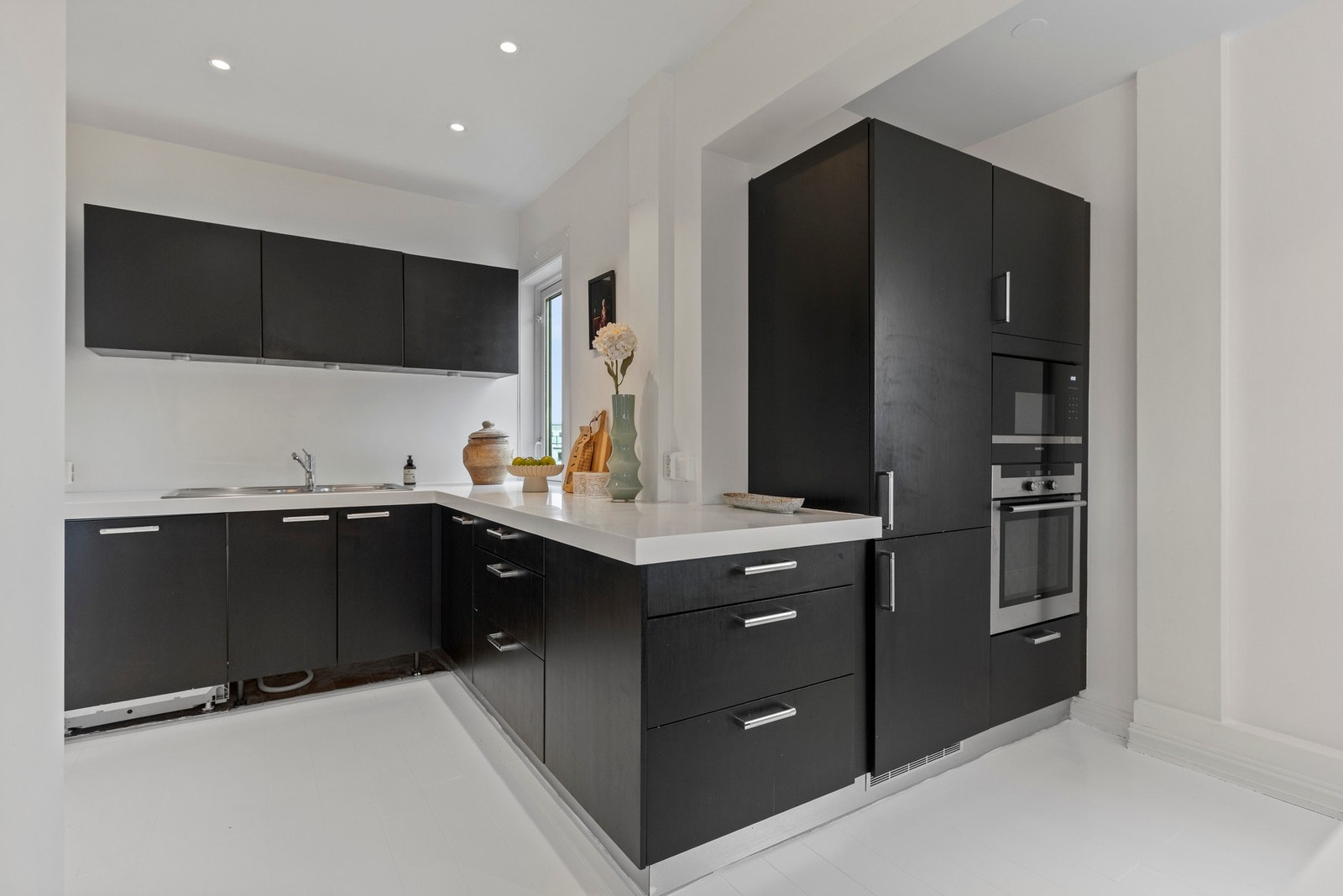 Pent Invita kjøkken med glatte fronter. Her er det rikelig med benkeplass samt gode oppbevaringsmuligheter i over- og underskap. Galleribilde