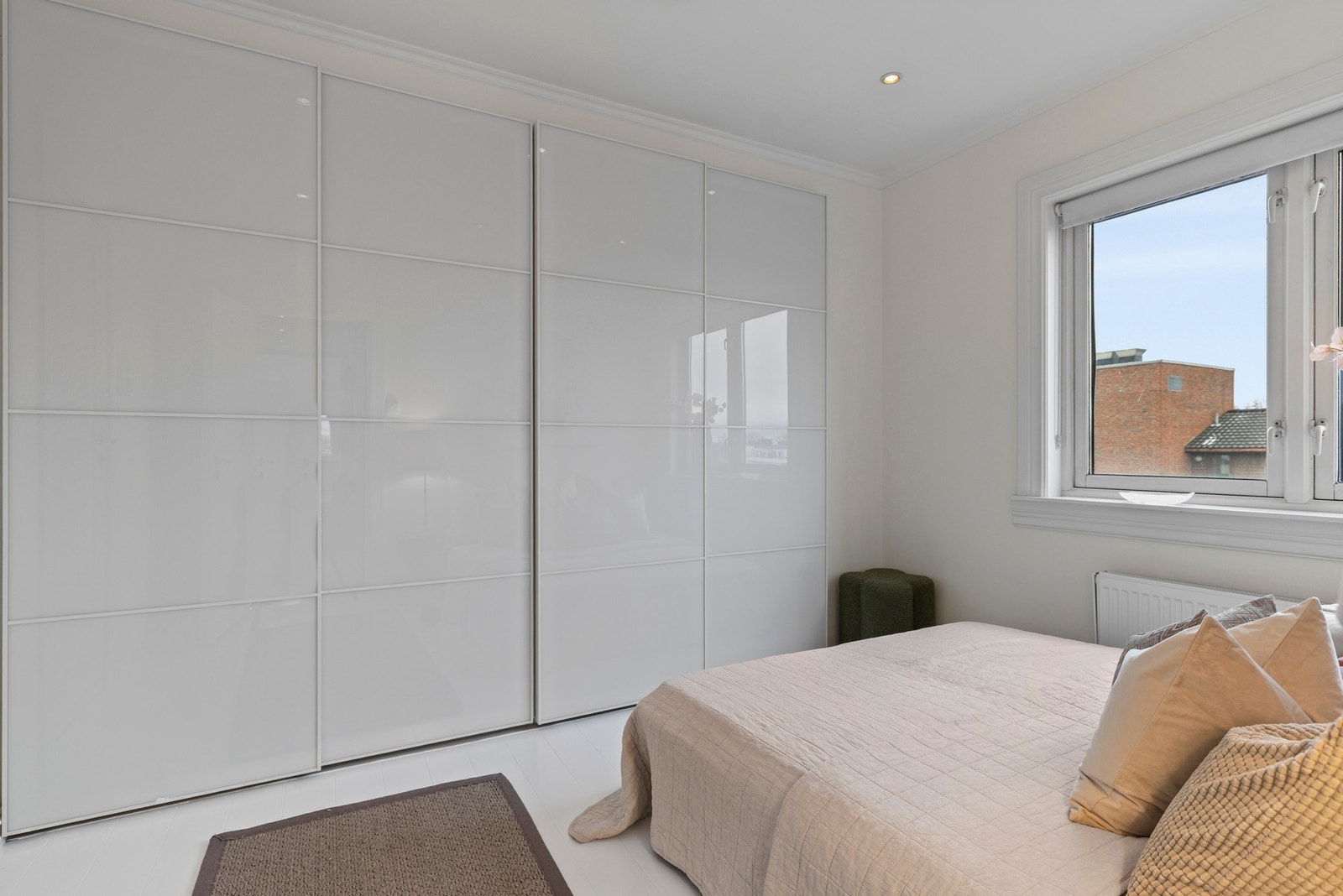 Rommet er innredet med en stor plassbygd skyvedørsgarderobe som gir praktisk oppbevaringsplass for klær og sengetøy, og bidrar til et ryddig og organisert rom. Galleribilde