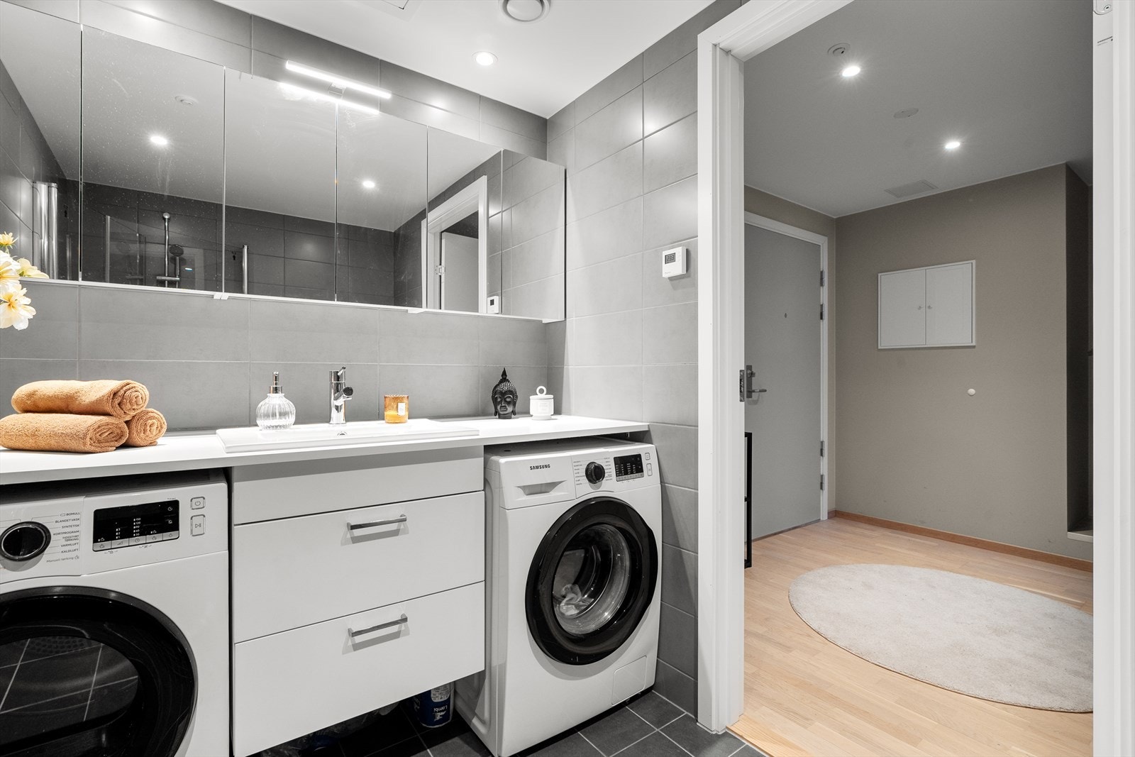 Servant med underskap, speilskap og opplegg for vaskemaskin gjør badet komplett. Galleribilde