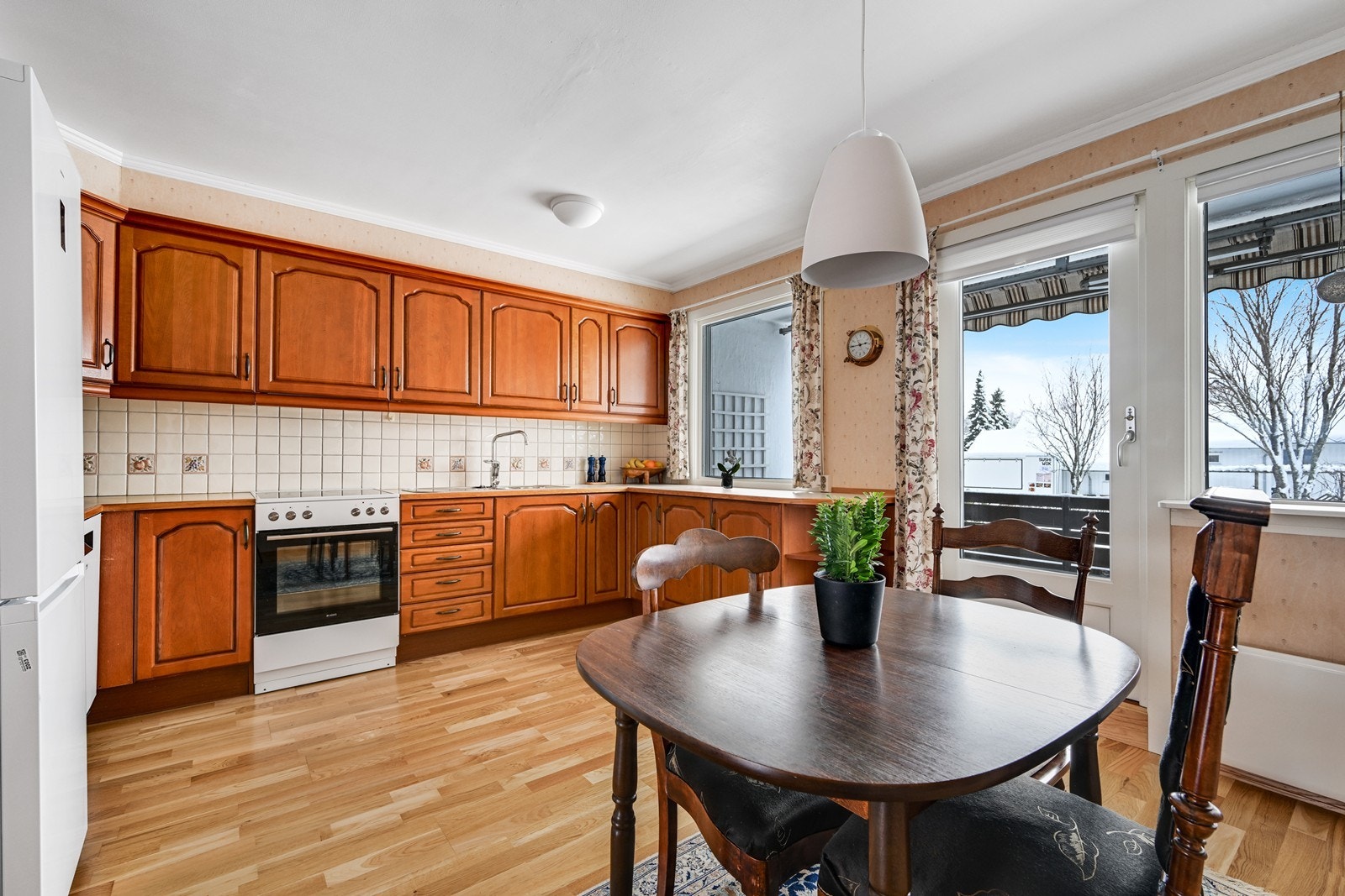 Kjøkken med spiseplass og utgang til vestvendt overbygget balkong. Galleribilde