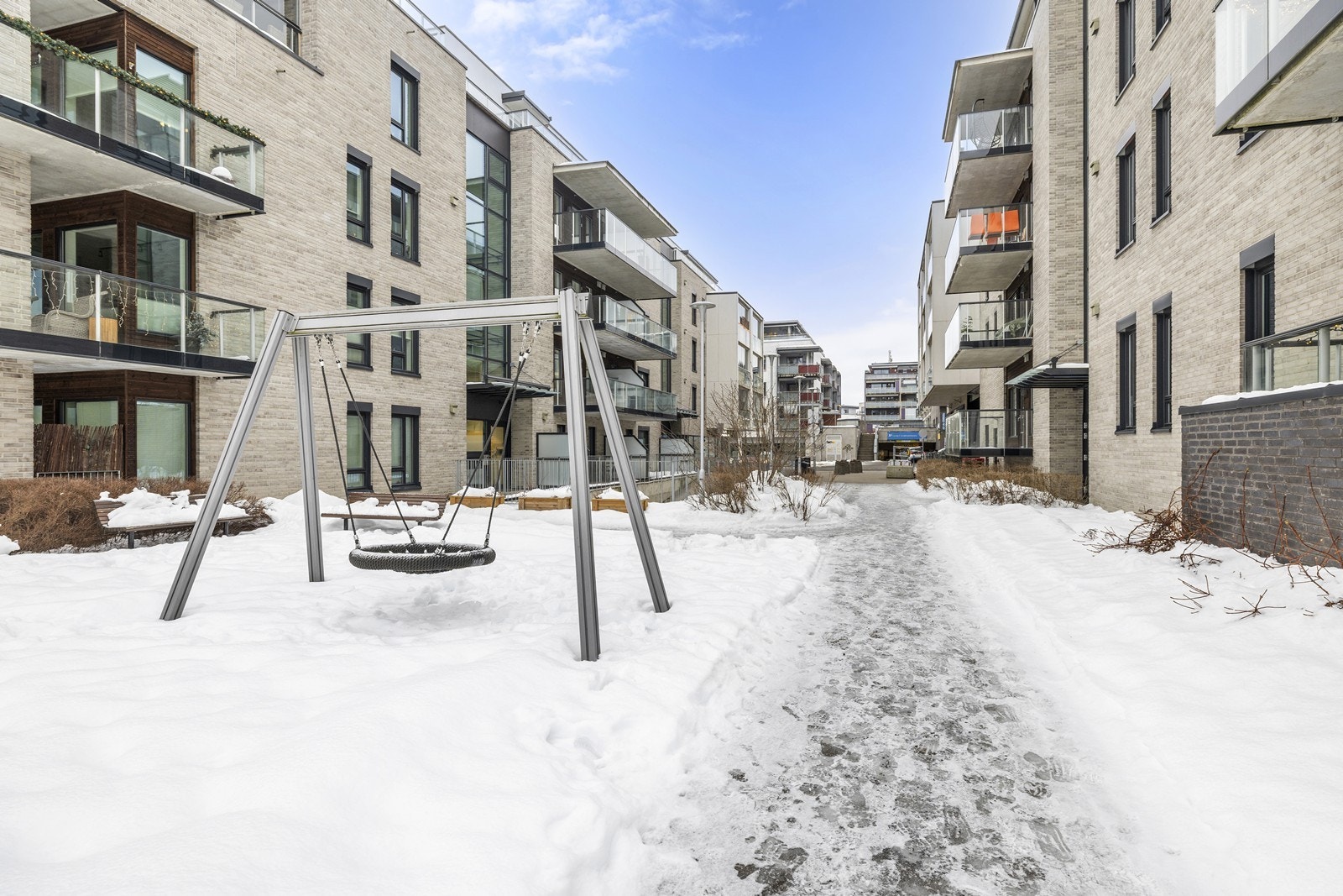 Sameiets tomt er pent opparbeidet med plen, interne gangveier og lekeapparater. Galleribilde