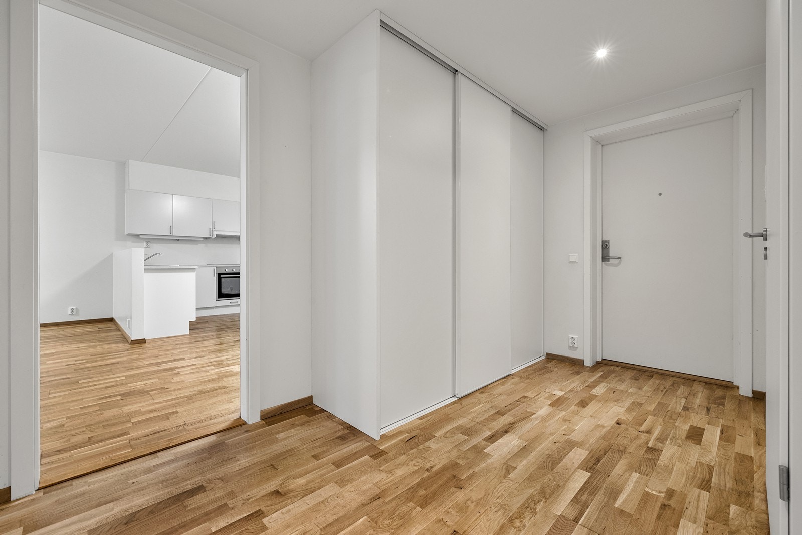 Lys og romslig entré med skyvedørsgarderobe til oppbevaring. Galleribilde