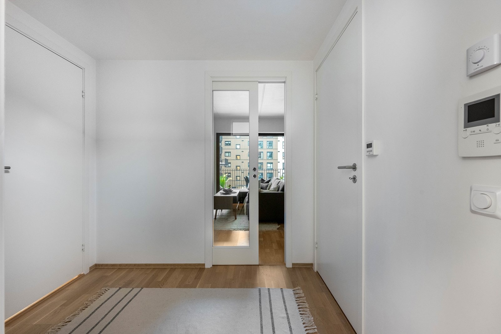 Skyvedør med glass gir fleksibilitet mellom entréen og stuen, samtidig som den slipper inn lys. Galleribilde