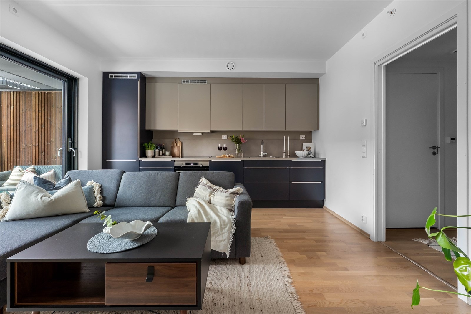 Parkettgulv og malte vegger gir en moderne og tidløs stil i oppholdsrommet. Galleribilde