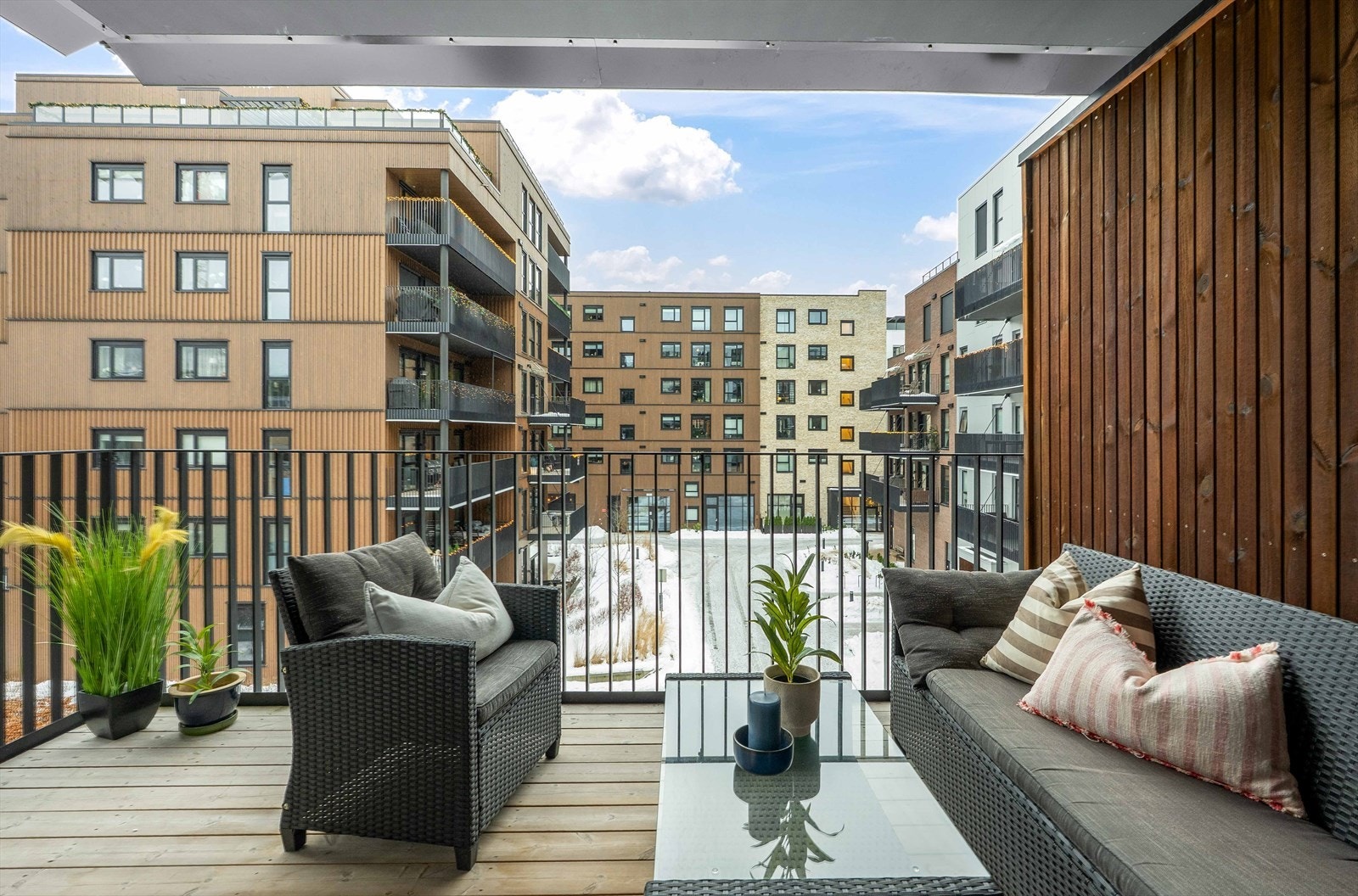 Utsyn mot fellesområde gir en åpen følelse fra balkongen, med romslig plass til møblering. Balkongen er overbygd. Galleribilde