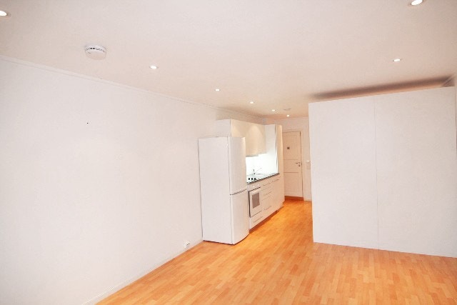 Åpen stue- og kjøkkenløsning med inngang til bad innerst i leiligheten. Galleribilde