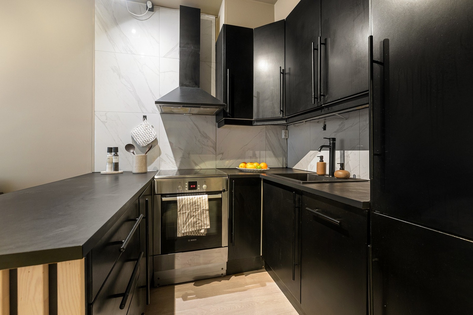 Kjøkkenet er utstyrt med integrerte hvitevarer, herunder kjøl/fryseskap, oppvaskmaskin og stekeovn, noe som gir et helhetlig og ryddig uttrykk. Galleribilde