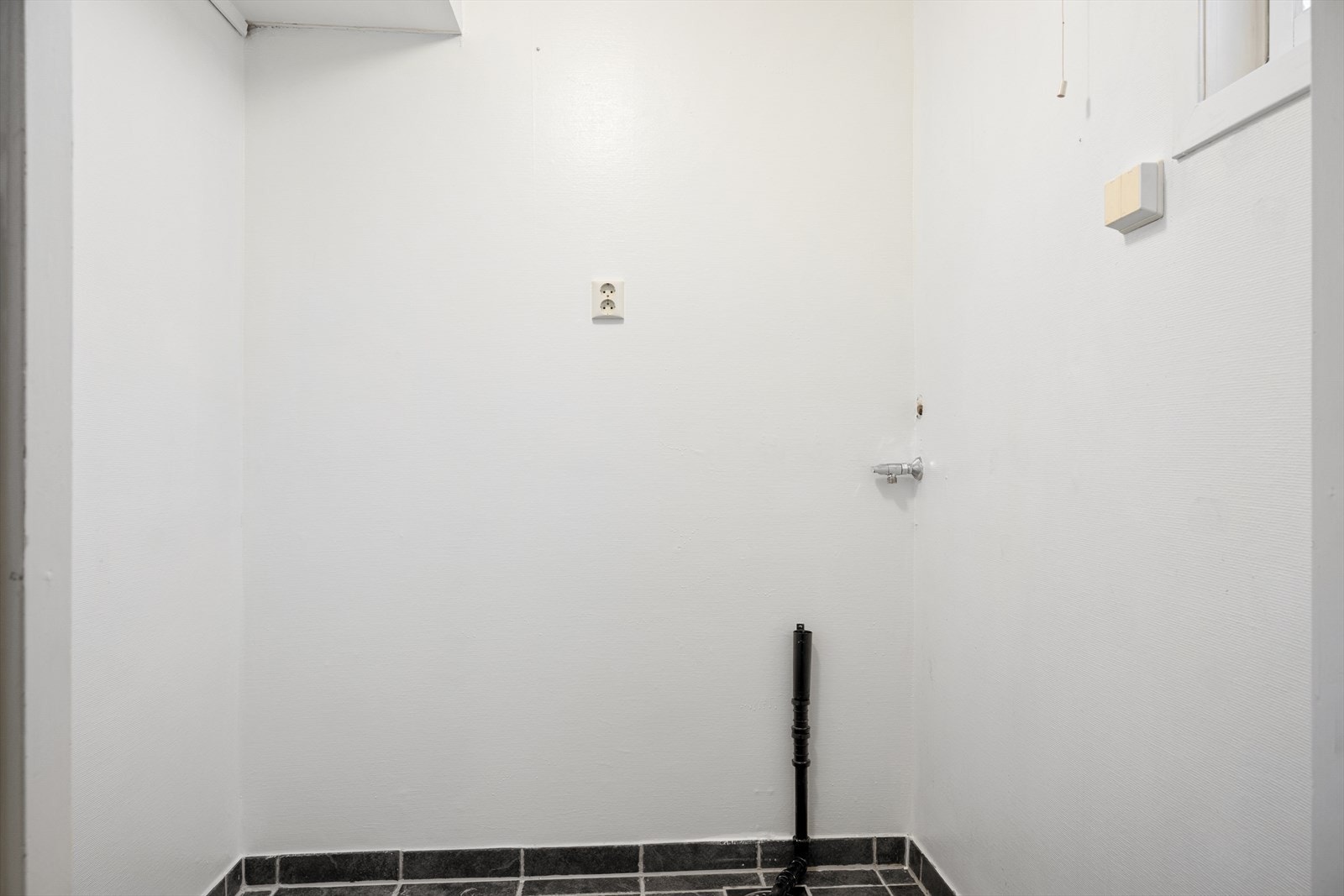 Ved inngangspartiet finner man også praktisk vaskerom. Vaskerommet har fliser på gulv og opplegg for vaskemaskin. Galleribilde