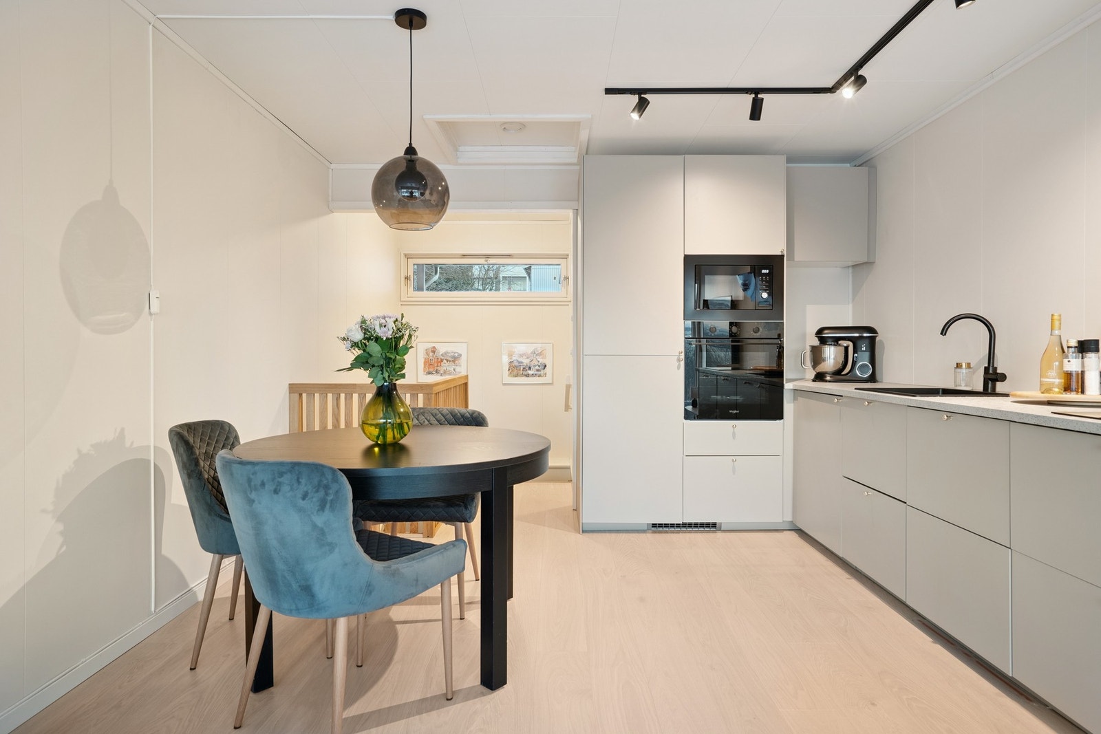 Montert lysskinne i tak over stue/kjøkken og moderne taklampe over spisebord. Galleribilde