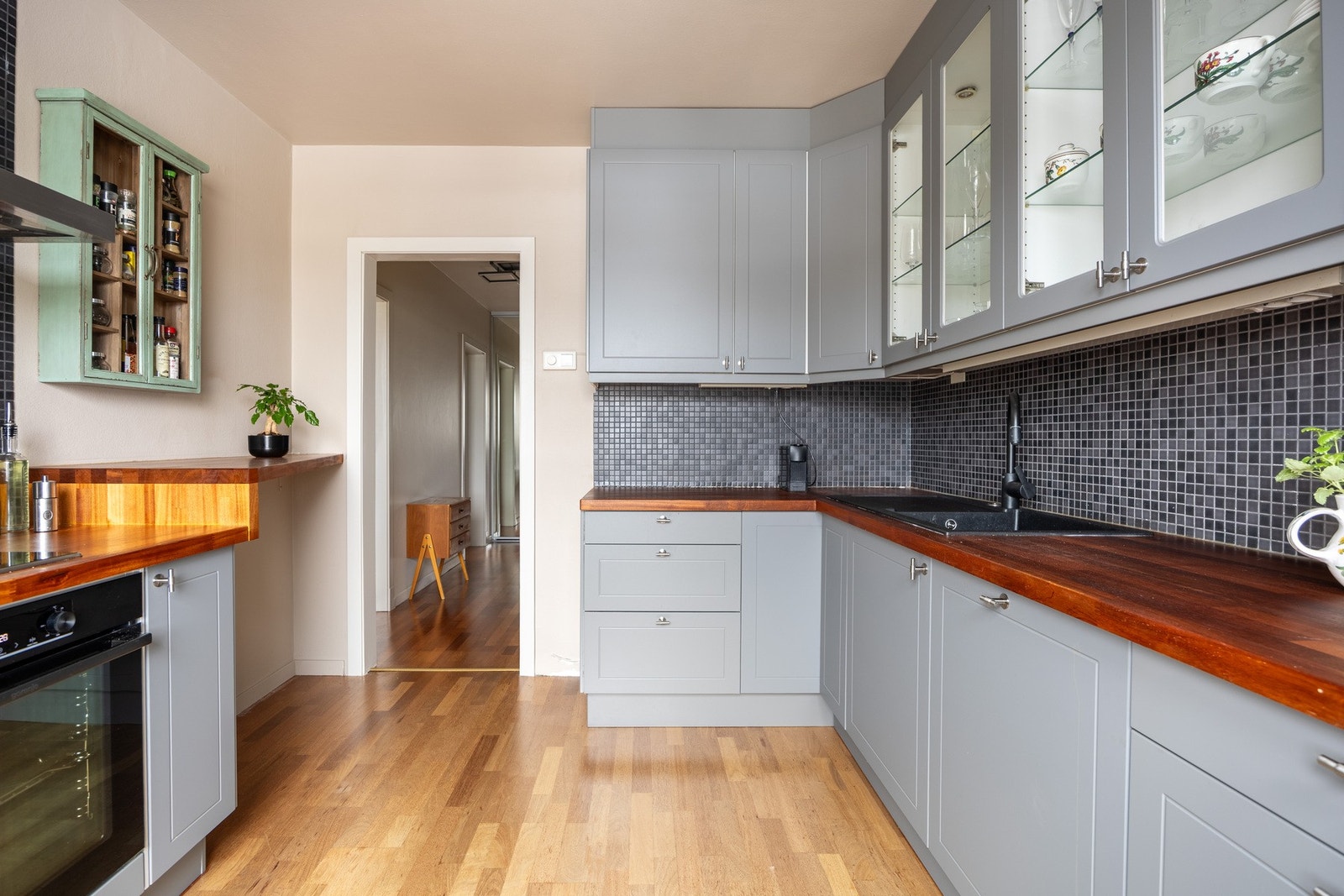 Kjøkkenet har profilerte fronter fra 2025 og benkeplate av heltre med nedsenket oppvaskkum og ett-greps armatur. Kjøkkenet har frittstående kjøleskap og fryser, samt integrerte hvitevarer. Galleribilde