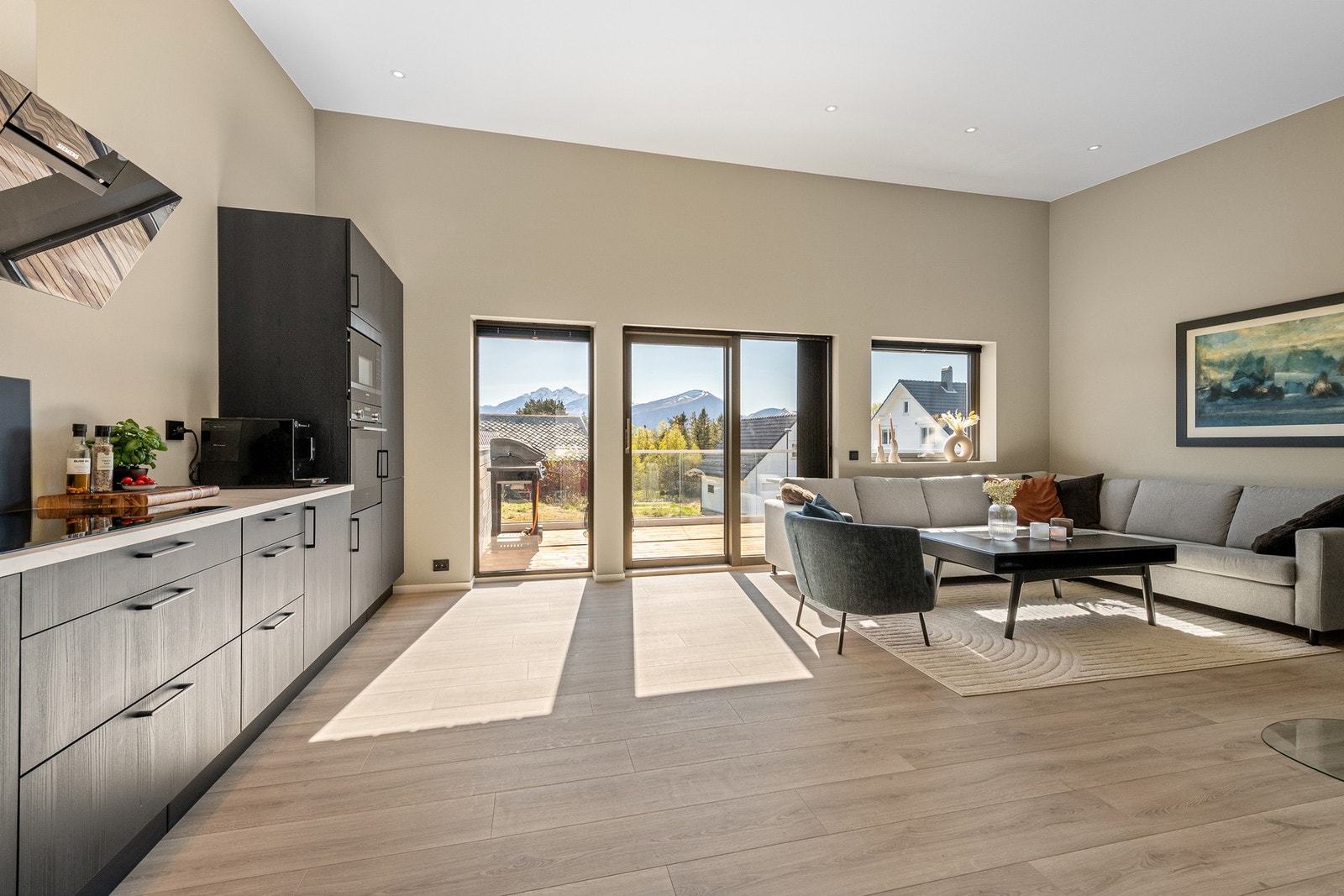 Lys stue med åpen kjøkkenløsning, store vindusflater og direkte utgang til en sydvendt veranda. God takhøyde. Galleribilde