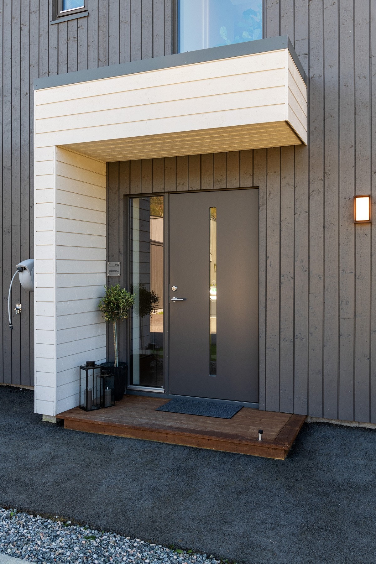 Pent overbygd inngangsparti. Det er vannutkaster på vegg. Galleribilde