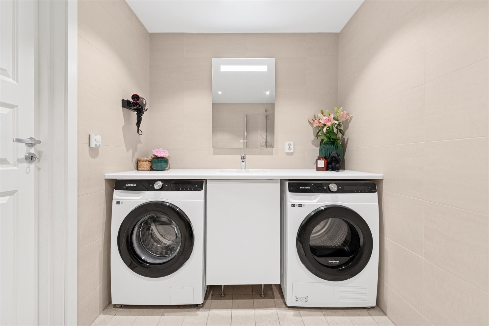 Praktisk servant over heldekkende benkeplate, med praktisk nisje til vaskemaskin/tørketrommel på hver side under benk. Galleribilde