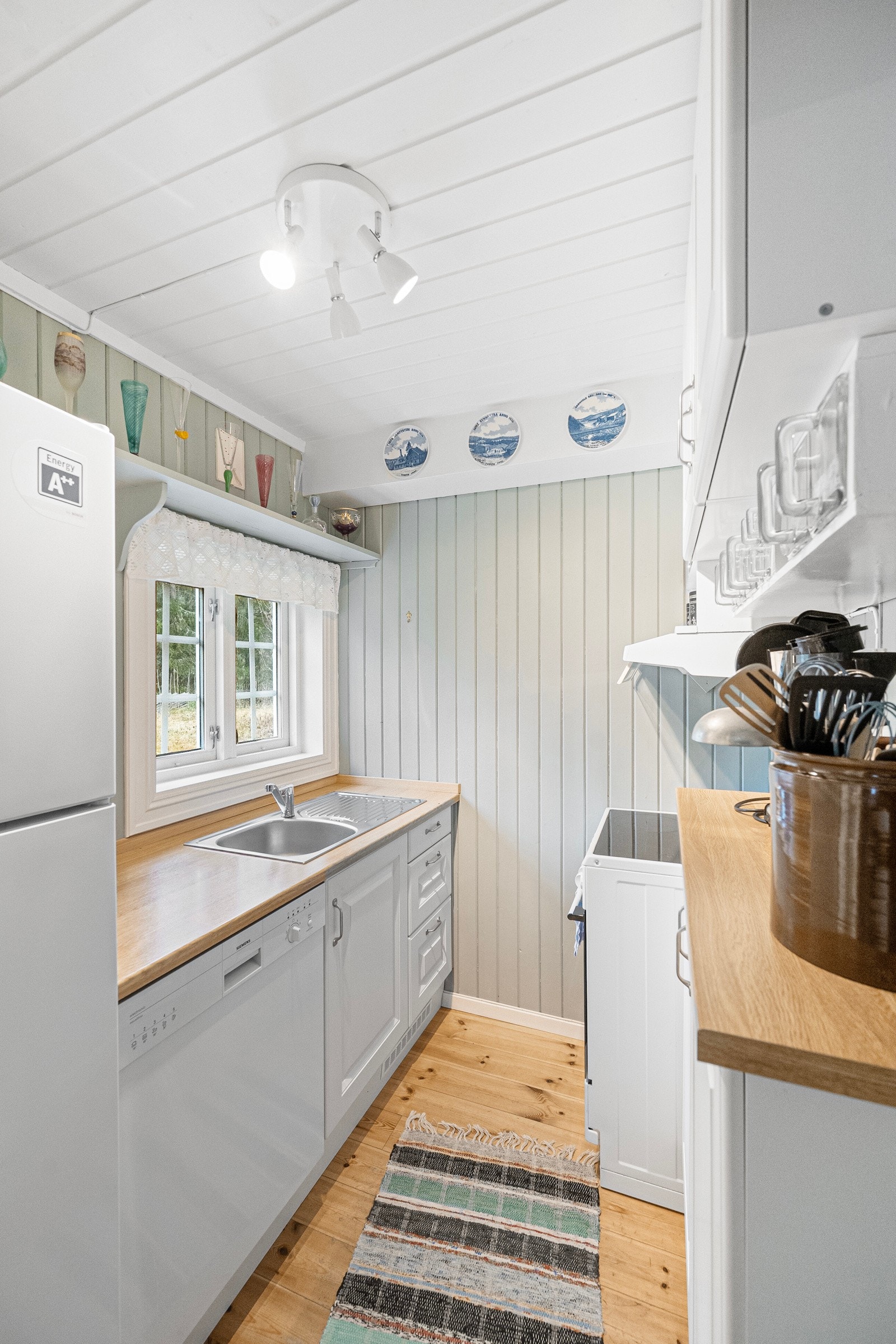 Kjøkkenet har plass til alt du trenger, komfyr, kjøl/frys og oppvaskmaskin, samt rikelig med skapplass i profilerte fronter Galleribilde