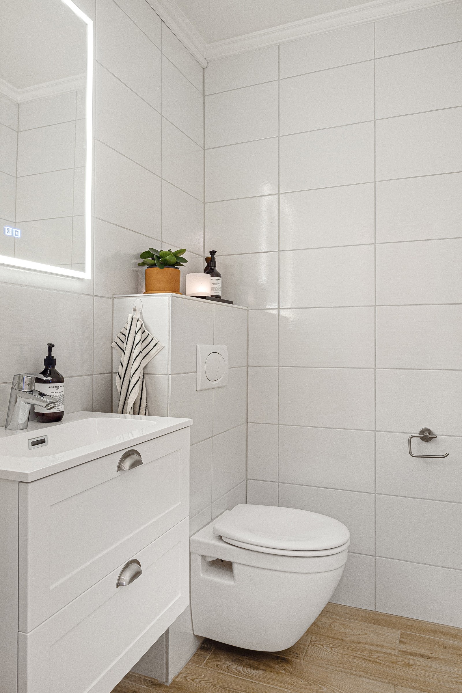 - Separat WC med vegghengt toalett, servant med skap og speil med lys - Galleribilde