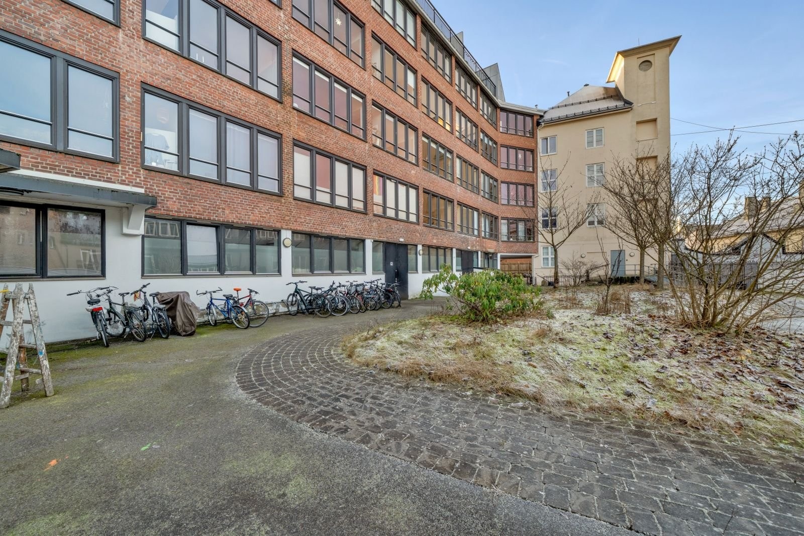 Fin og rolig bakgård. Fin kveldssol på benkene innerst i bakgården. Galleribilde