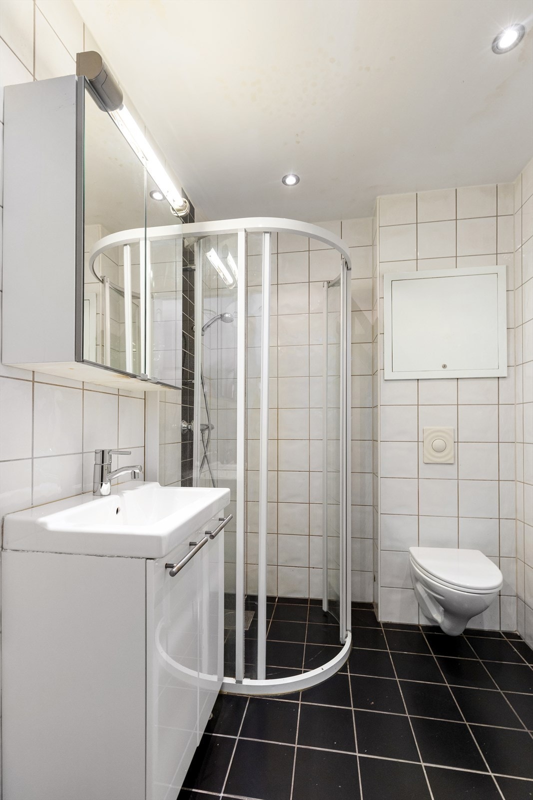 Helfliset bad med dusjkabinett og vegghengt toalett. Galleribilde